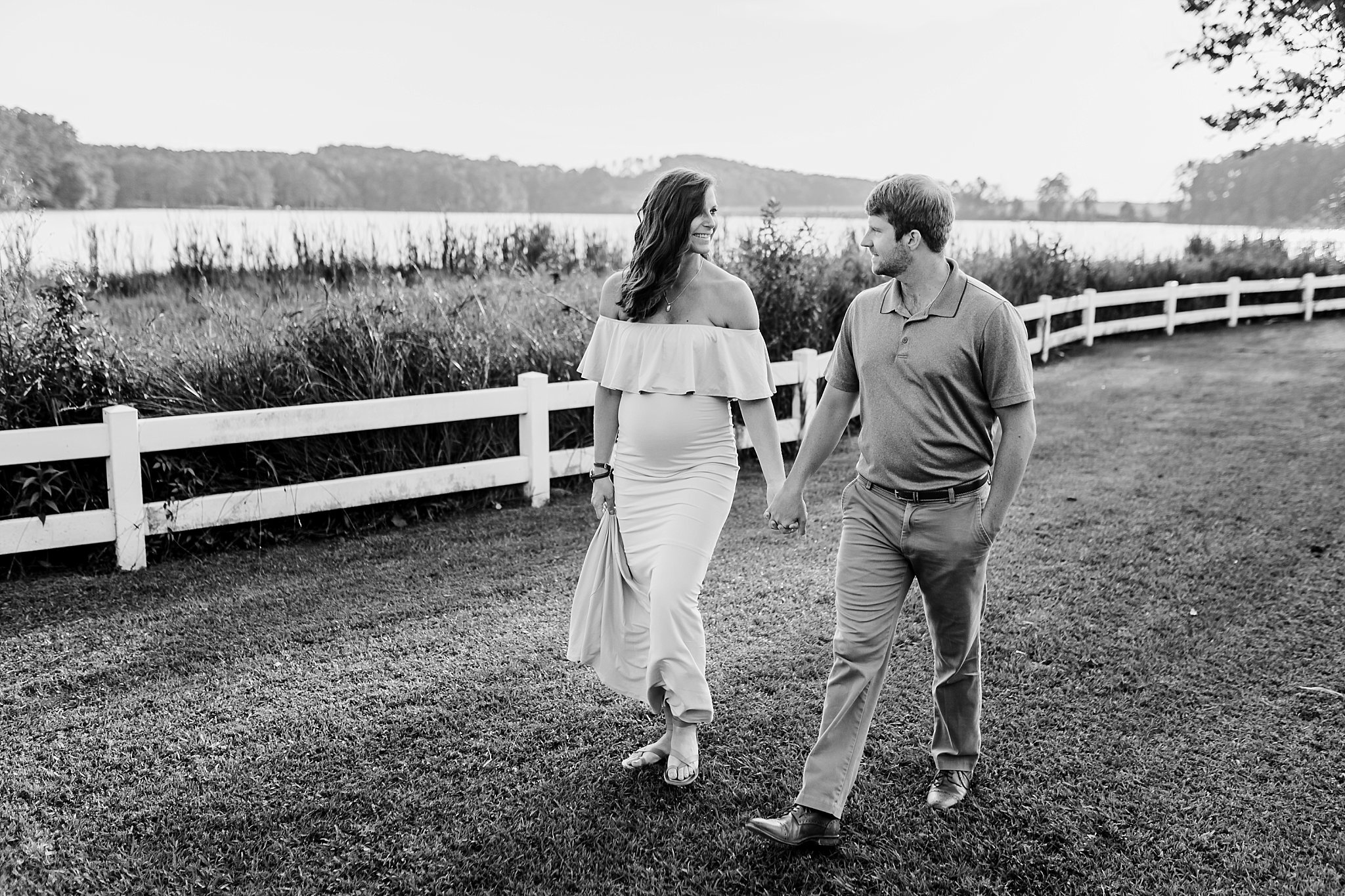 COuple walking through grass holding hands at Cauble Park in Acworth Georgia