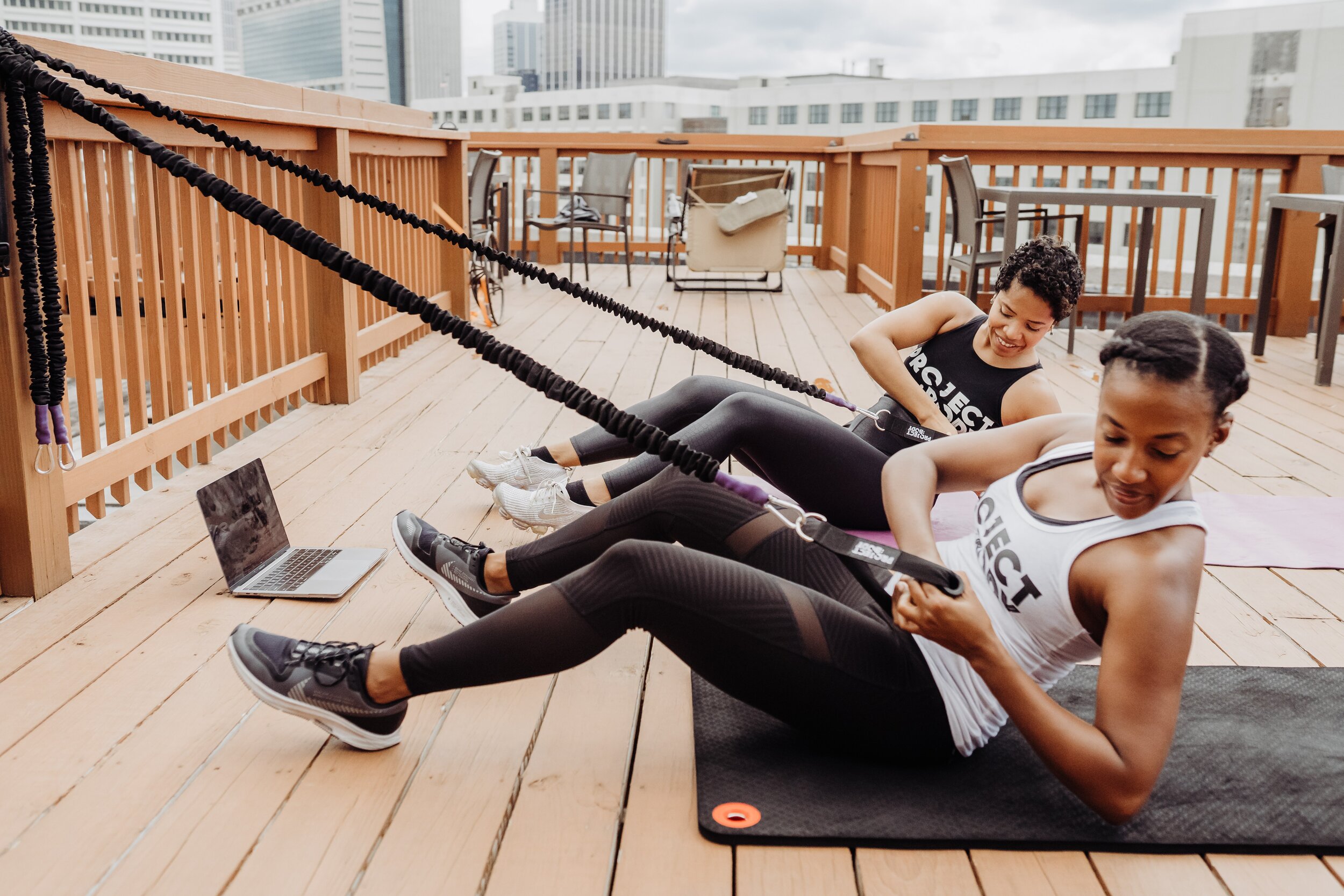 fitness instructors of project body doing a band workout on rooftop in Atlanta, GA