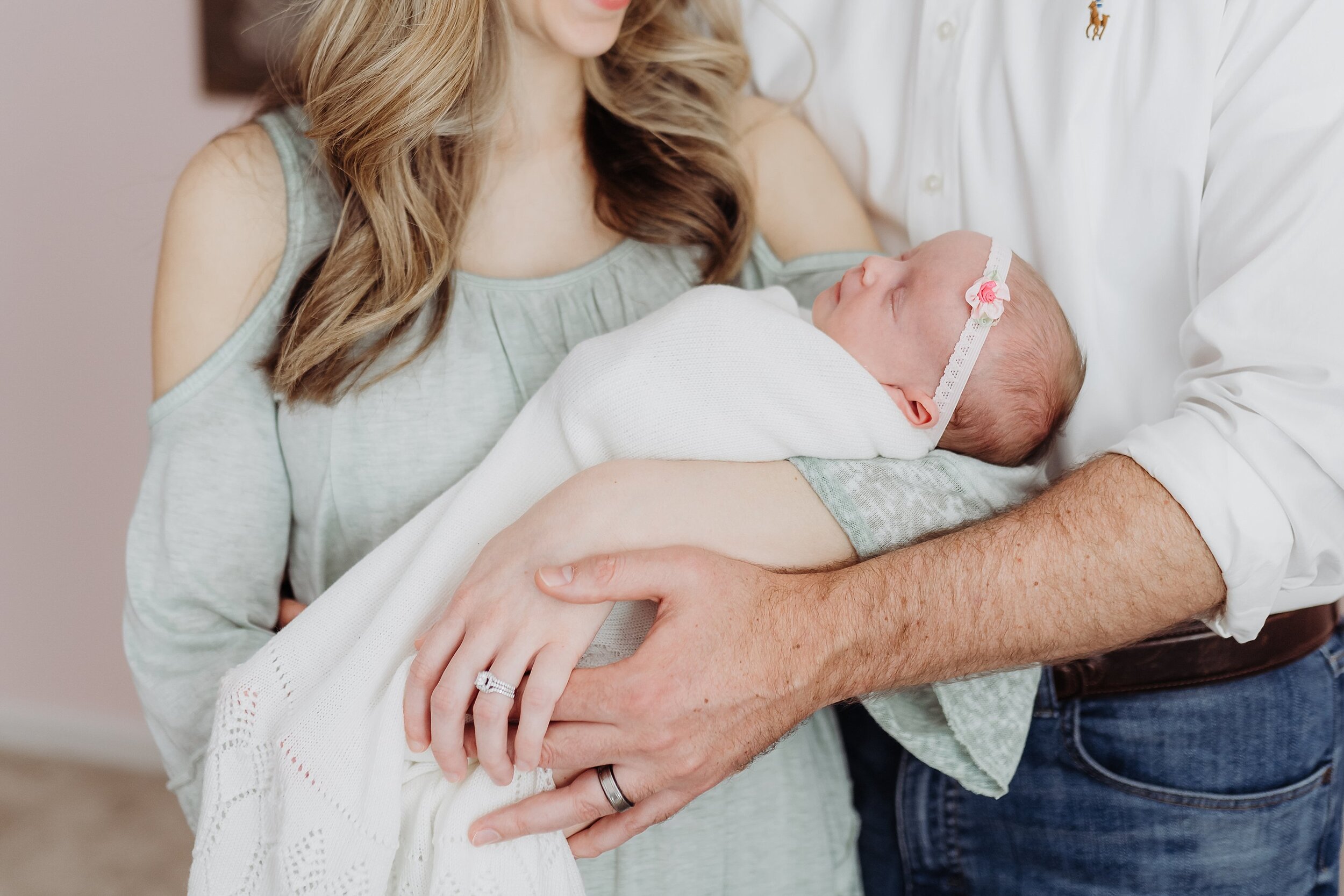 Baby girl in white blanket in moms arms