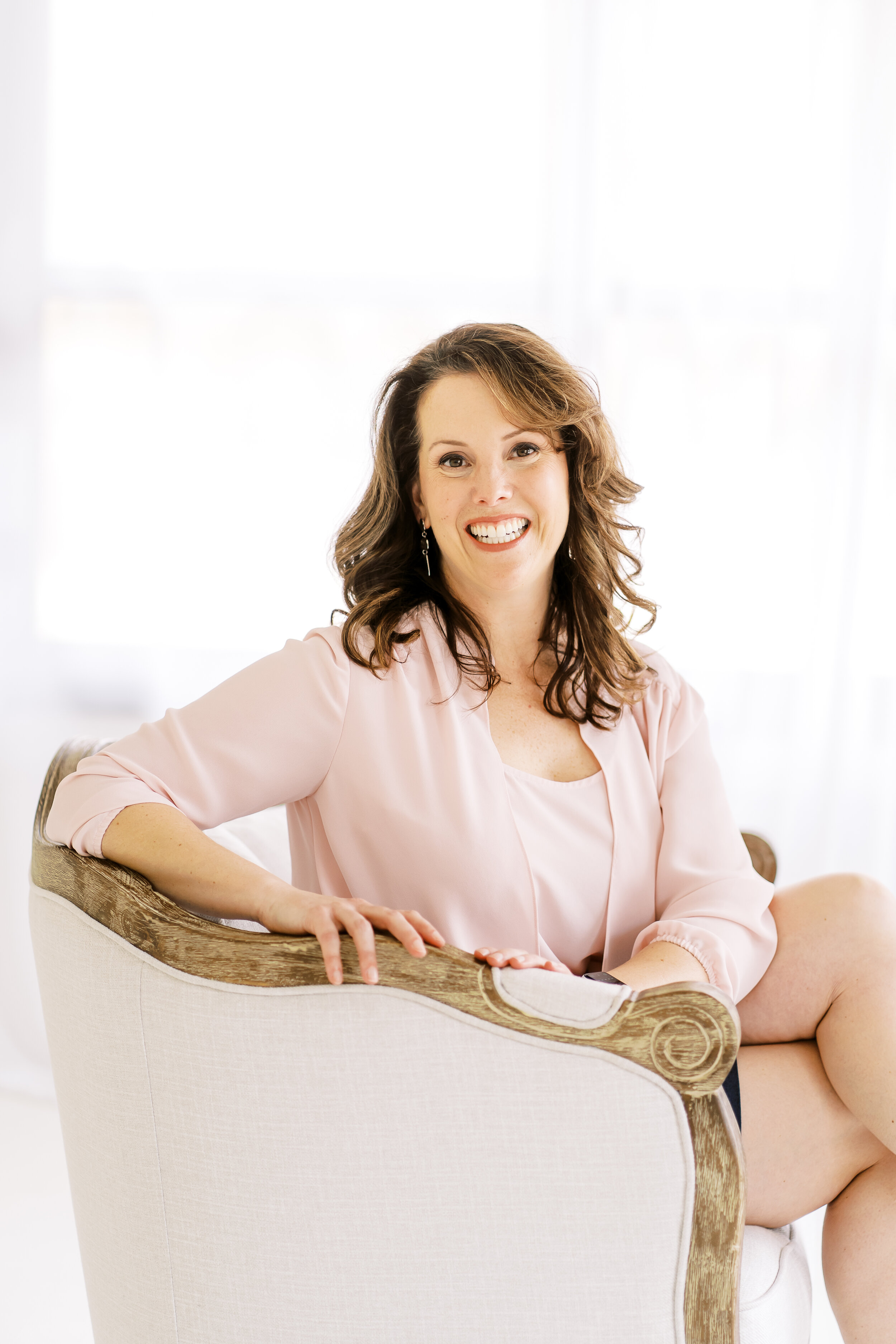 Personal brand photo of life coach sitting on chair in natural light studio in Woodstock, GA