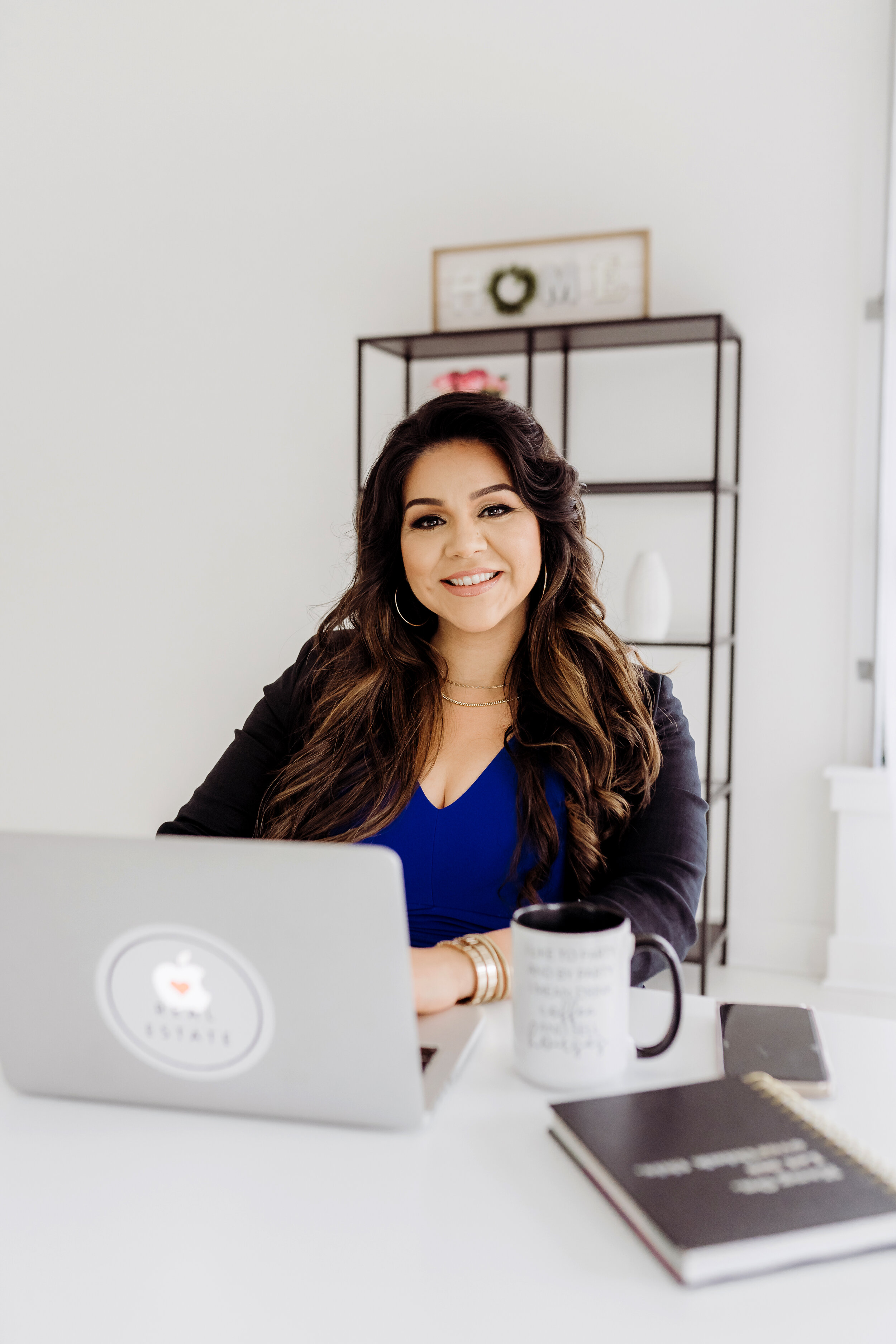 Realtor in blue dress and black jacket sitting at desk behind macbook Atlanta, GA Personal Brand Photo Session