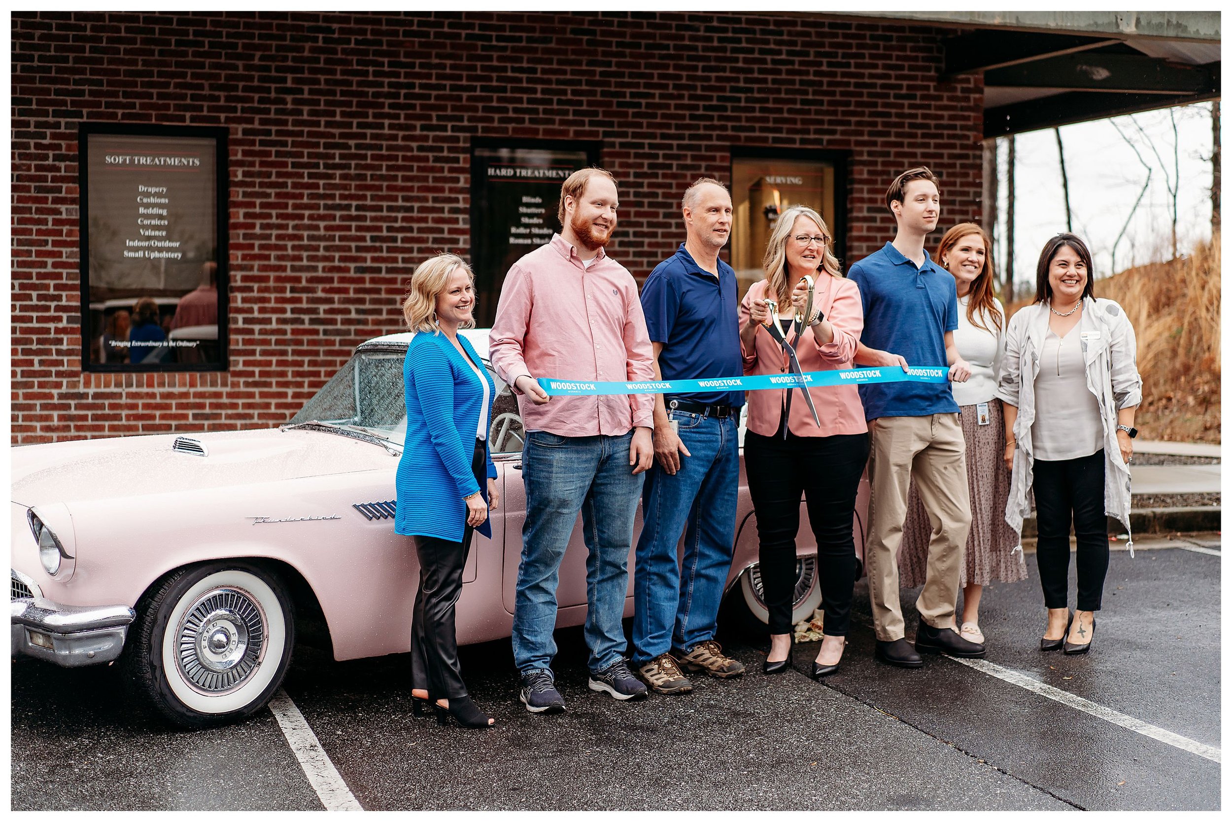 ribbon cutting in front of pink car for Woodstock, GA business event