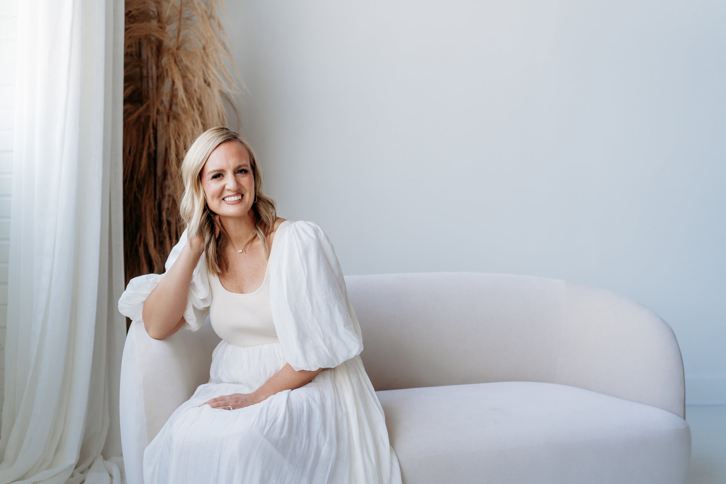 Photographer sitting on couch for headshot in Atlanta studio