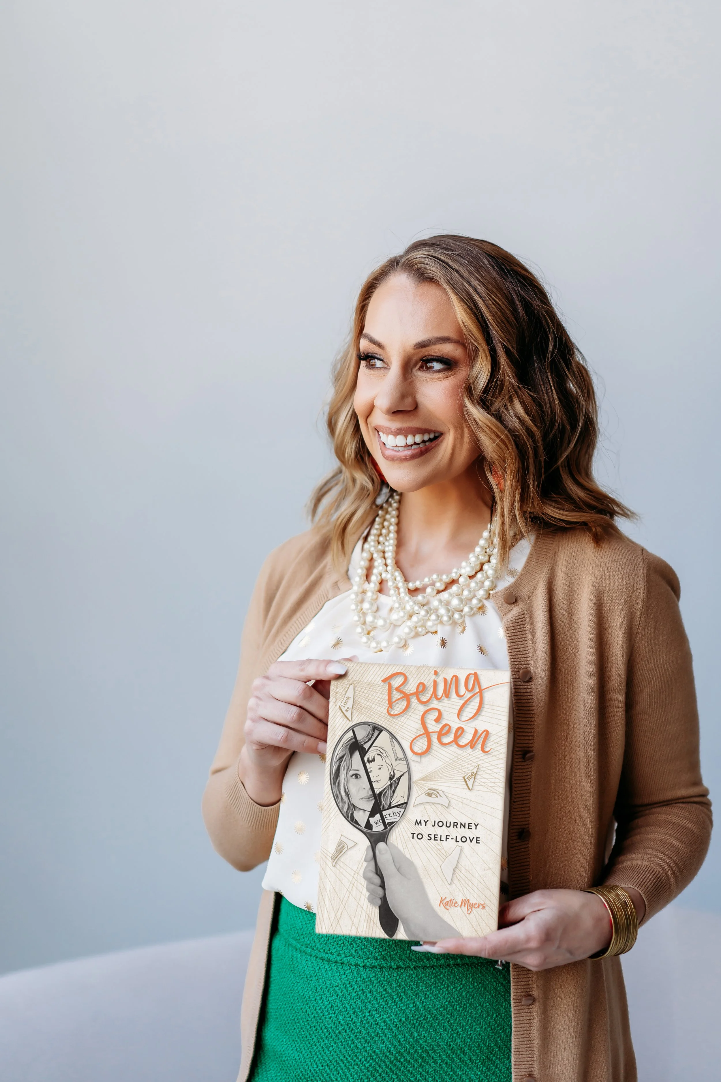 Lifestyle brand photo of Atlanta therapist holding book she authored