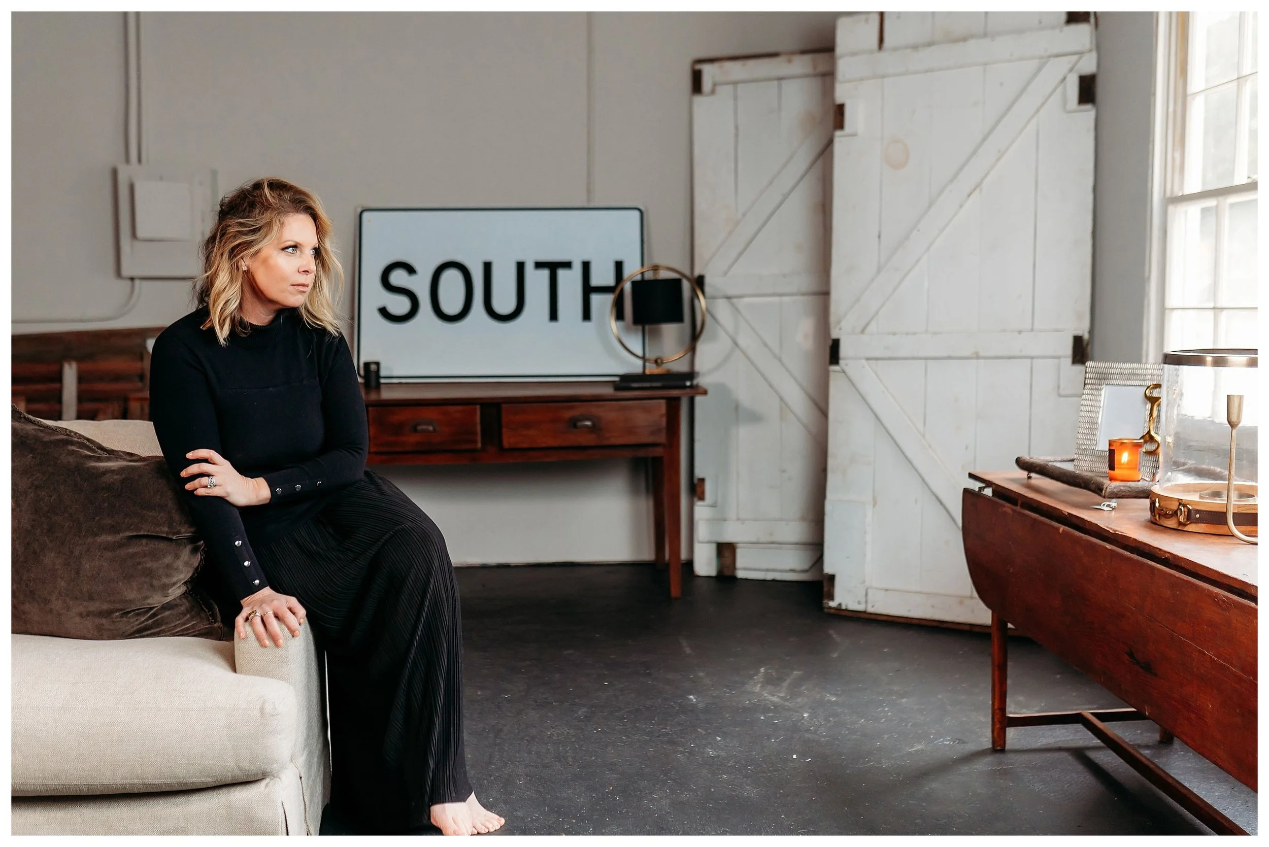 Interior designer in warehouse looking out window for brand photos with Adrienne Louise Photo + Films