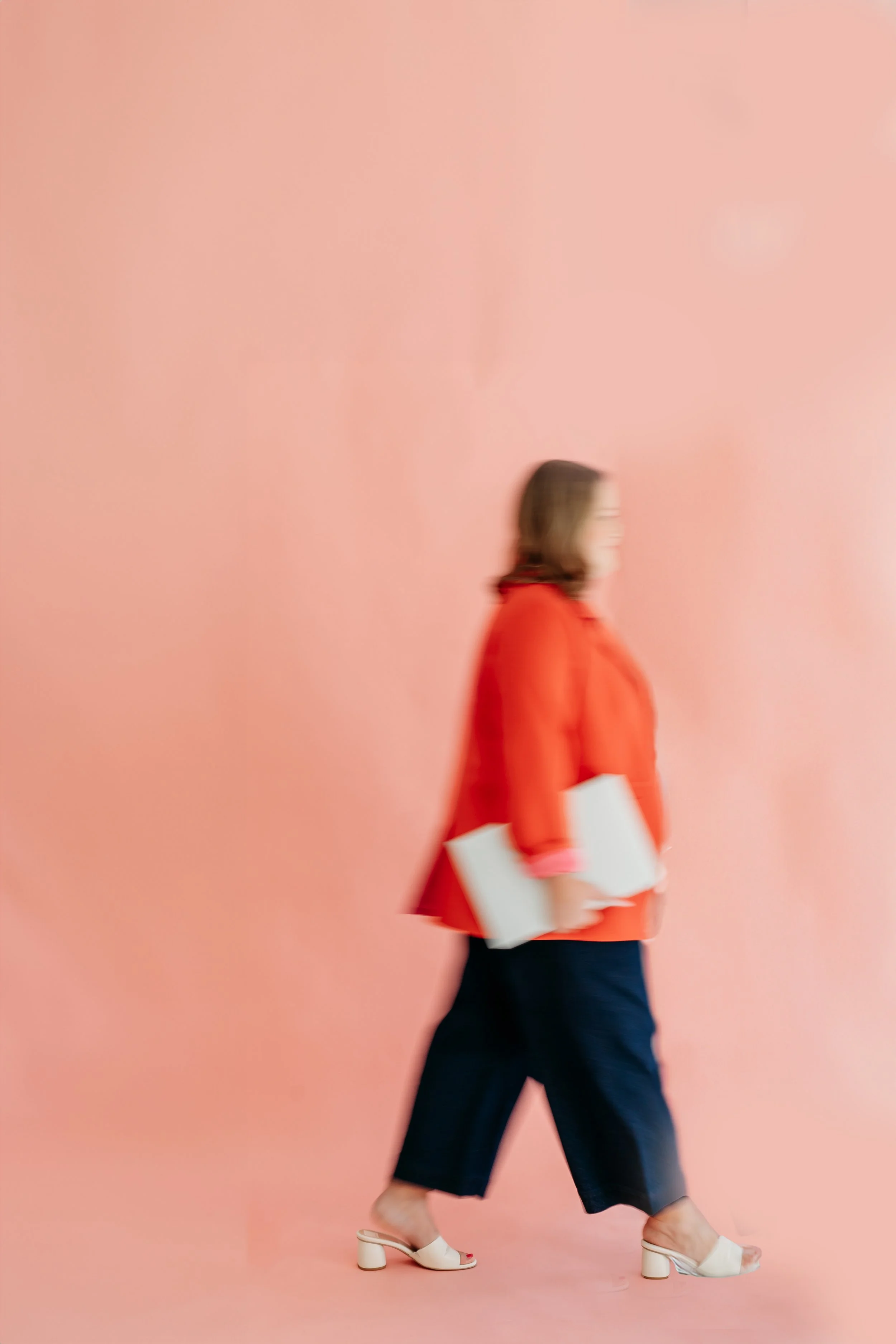 website designer walking across pink backdrop 