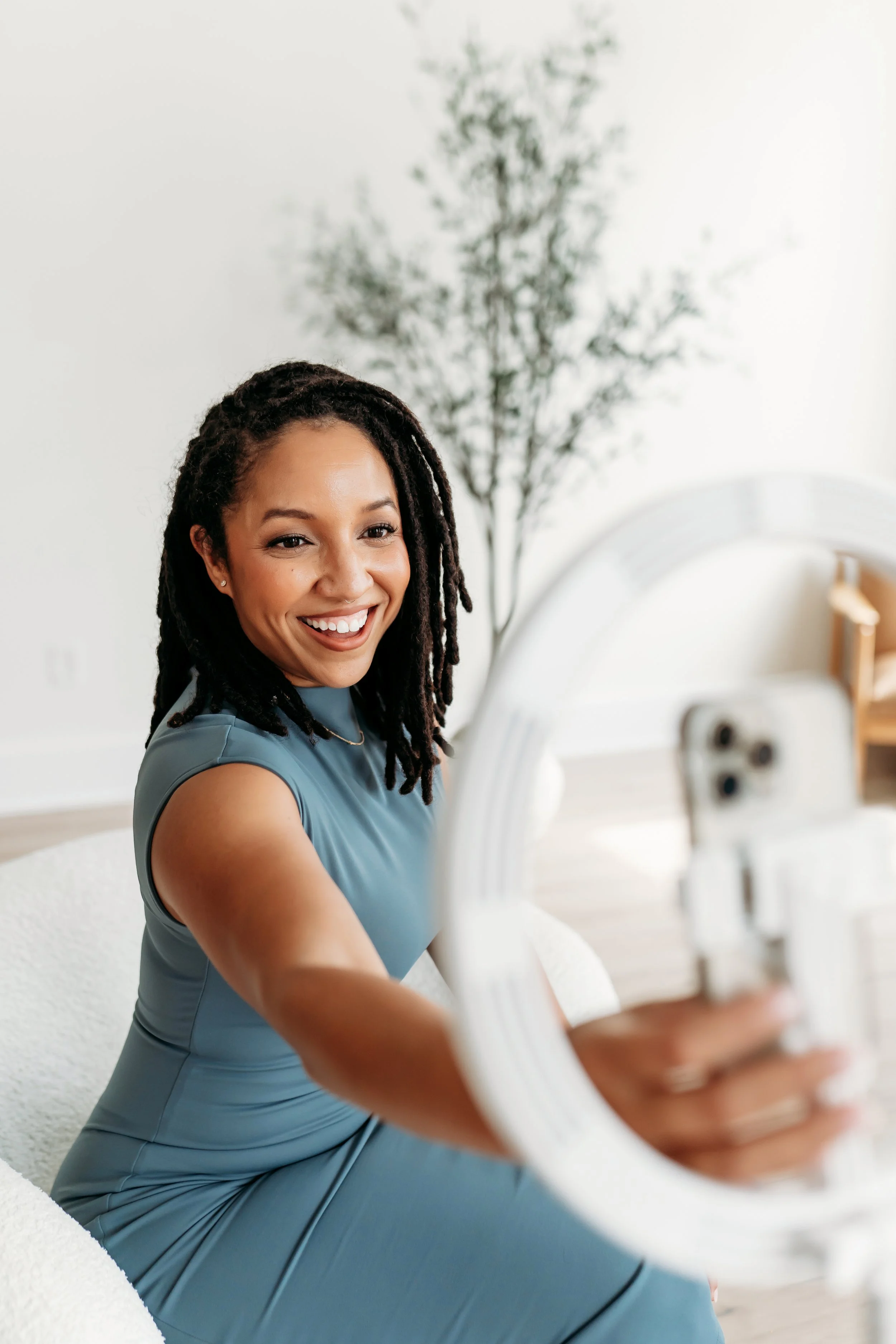 woman in blue dress using a ring light to create content during brand photo session