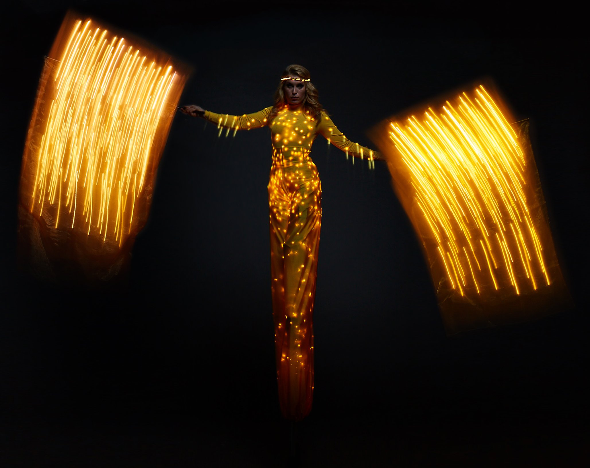 Colour Collection, illuminated stilt performance in yellow with flags, Divine Company.jpg
