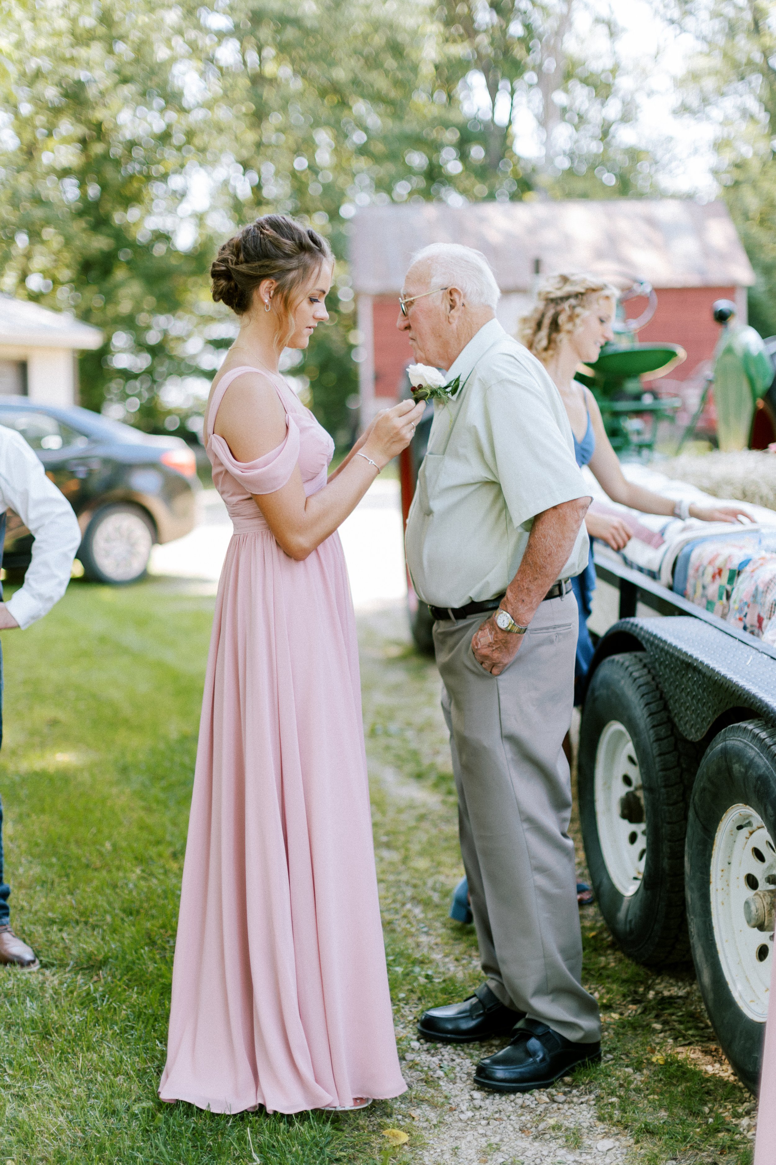 pinning boutonierre on grandpa before wedding