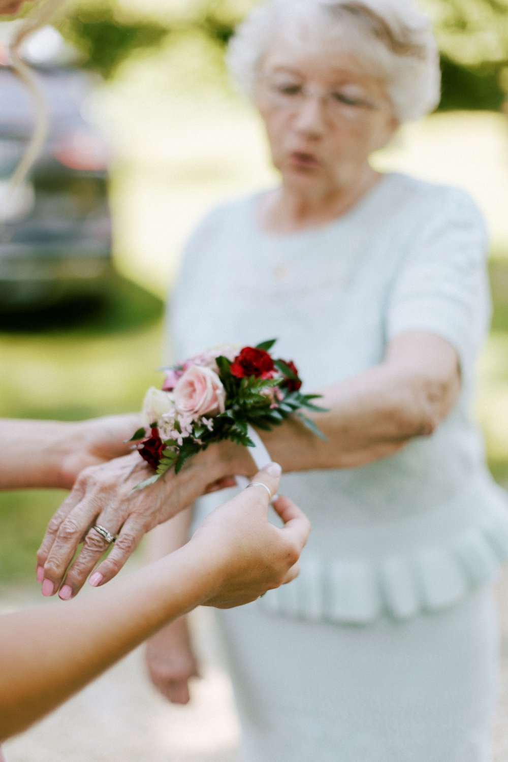 pinning on corsage at wedding