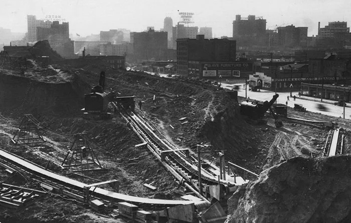 Electric shovels move dirt onto conveyor belts to be dumped into the Puget Sound at the Denny Hill regrade next to Fifth Avenue on Oct. 6, 1929. (Seattle Times Archive).