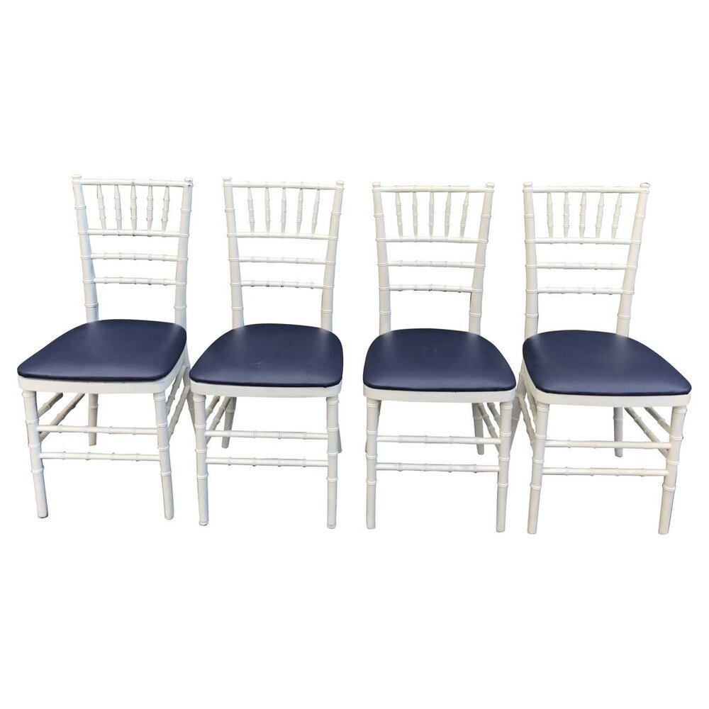 https://images.squarespace-cdn.com/content/v1/57d9bbf5bebafb20b92a6b04/1631578468511-E5WCNQZQZEV08GBJZ4NE/Set+of+Four+Classic+White+Wooden+Chiavari+Chairs+with+Navy+Seats1.jpg?format=1000w