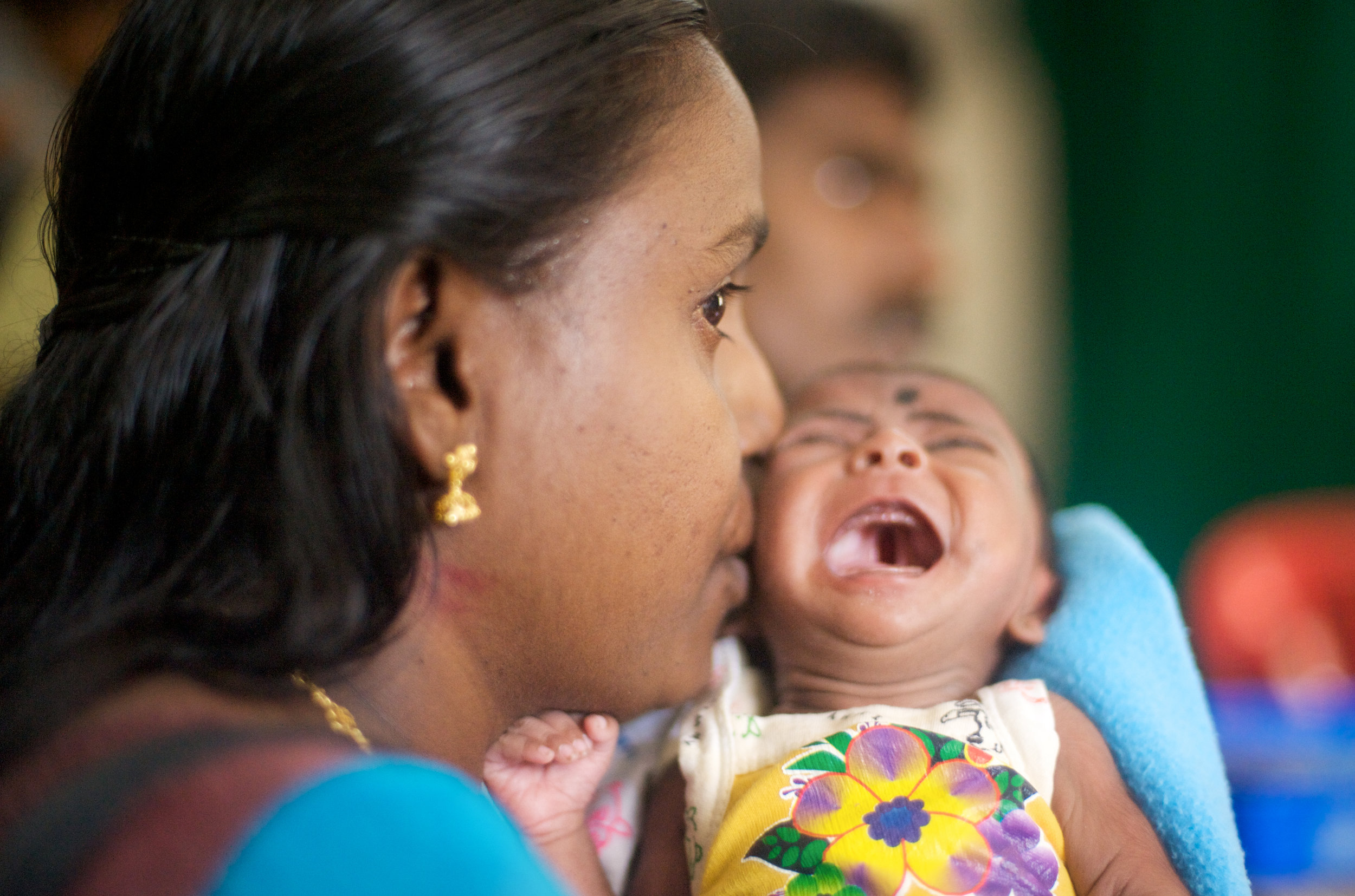  The consultation. A cleft palate, visible in the open mouth of a crying infant, brings a family to Dr. Adenwalla's clinic where he performs free corrective surgeries. 