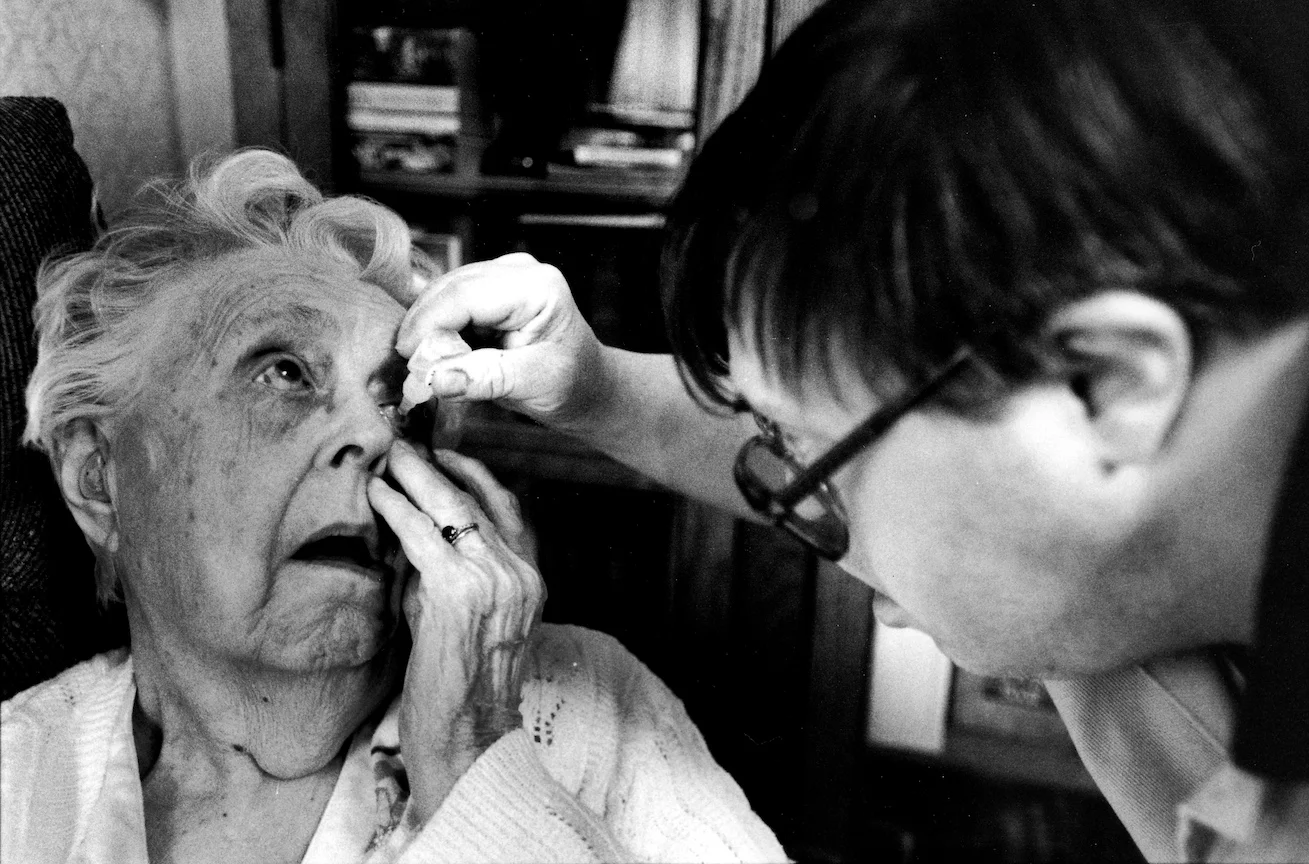John Joyce puts eyedrops in his mother Doris' eyes before bed in their home in Bowdoinham, Maine.