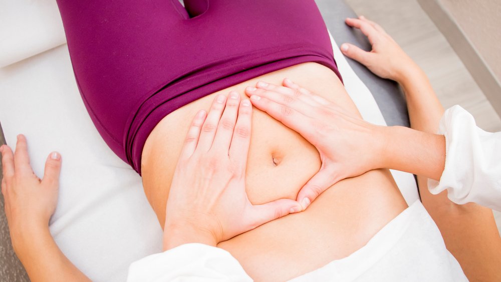woman laying down getting pelvic floor therapy from therapist