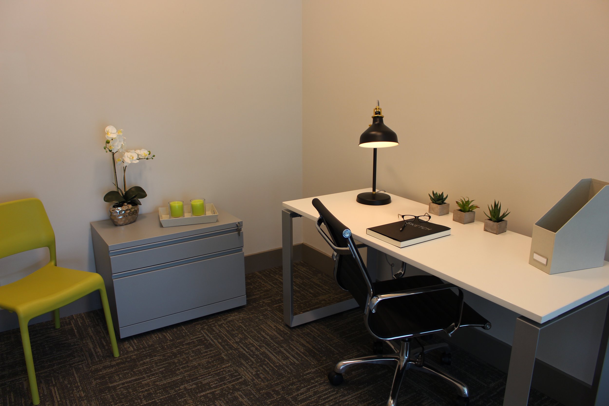 Picture of a private office with white and gray modern desk, office chair and desk lamp.