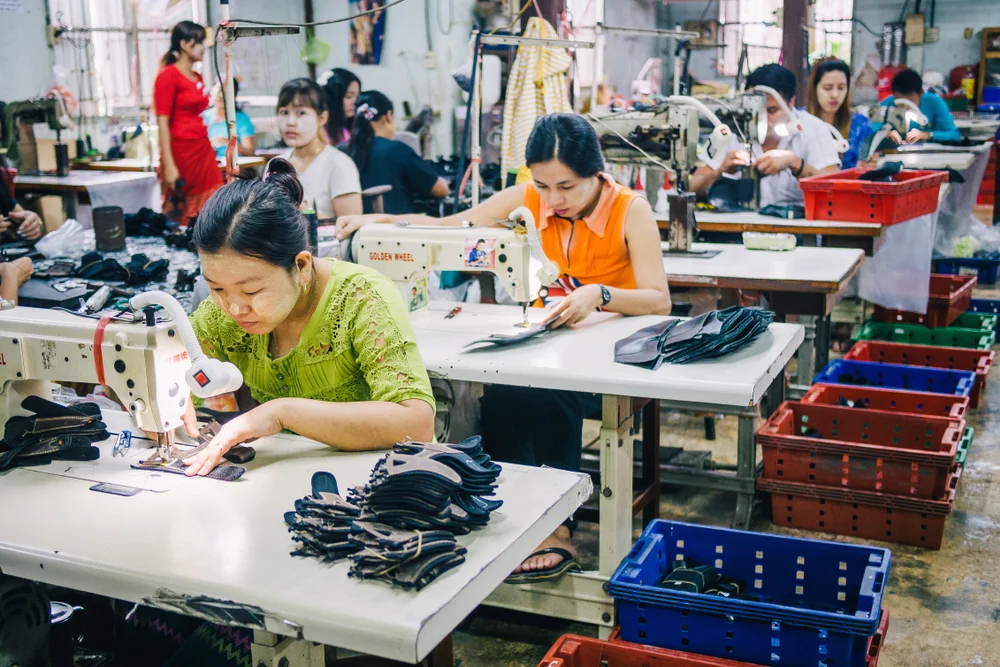 Burmese Female Migrant Workers Sewing Leather Shoes in thailand. catastrophe_OL/shutterstock