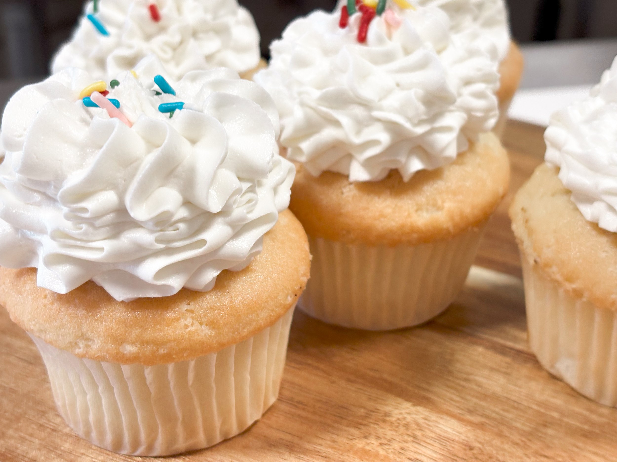100% gluten free vanilla cupcake with vanilla frosting and sprinkles that is baked with love