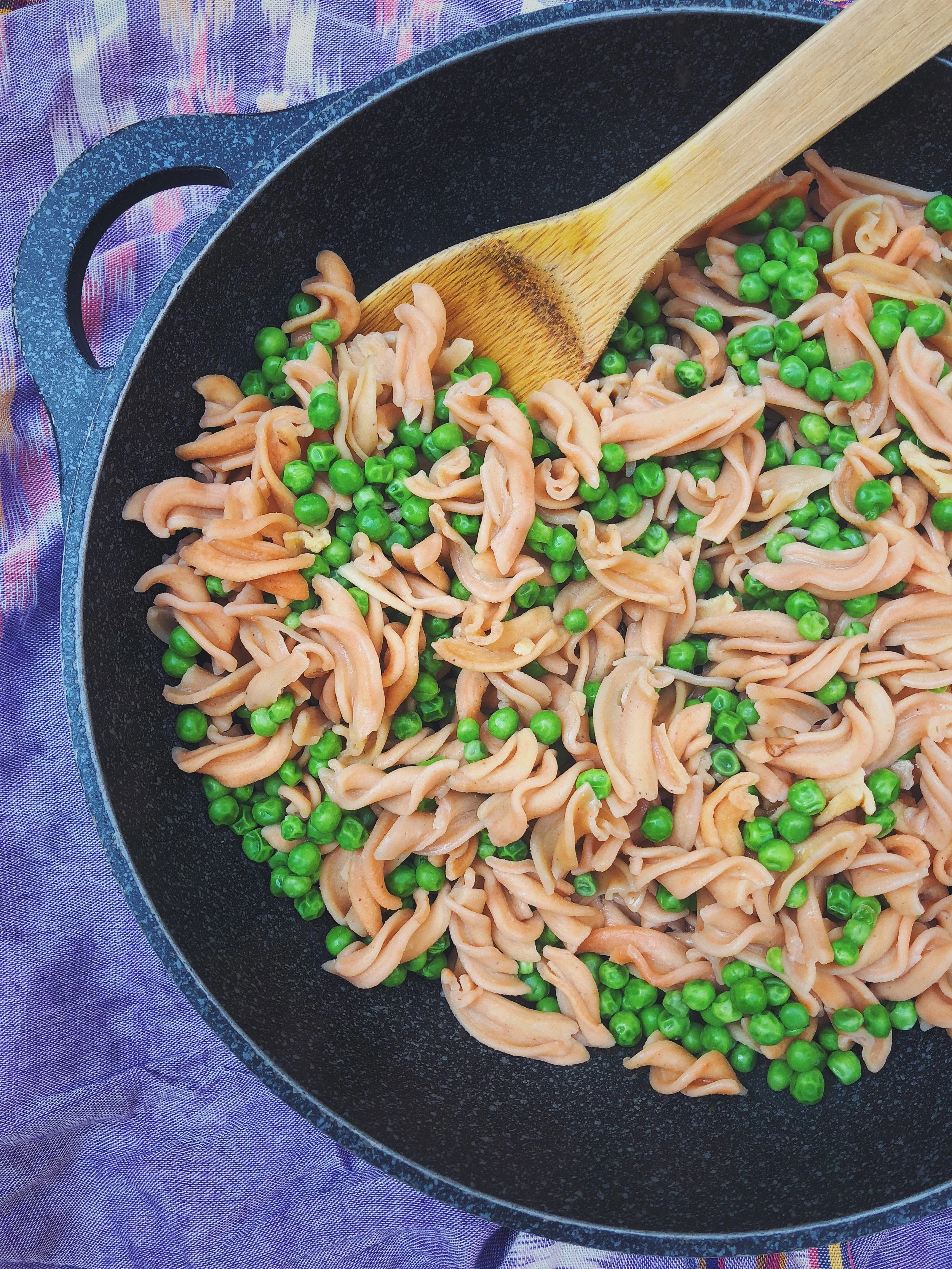 Simple lentil protein pasta with bright, green peas.