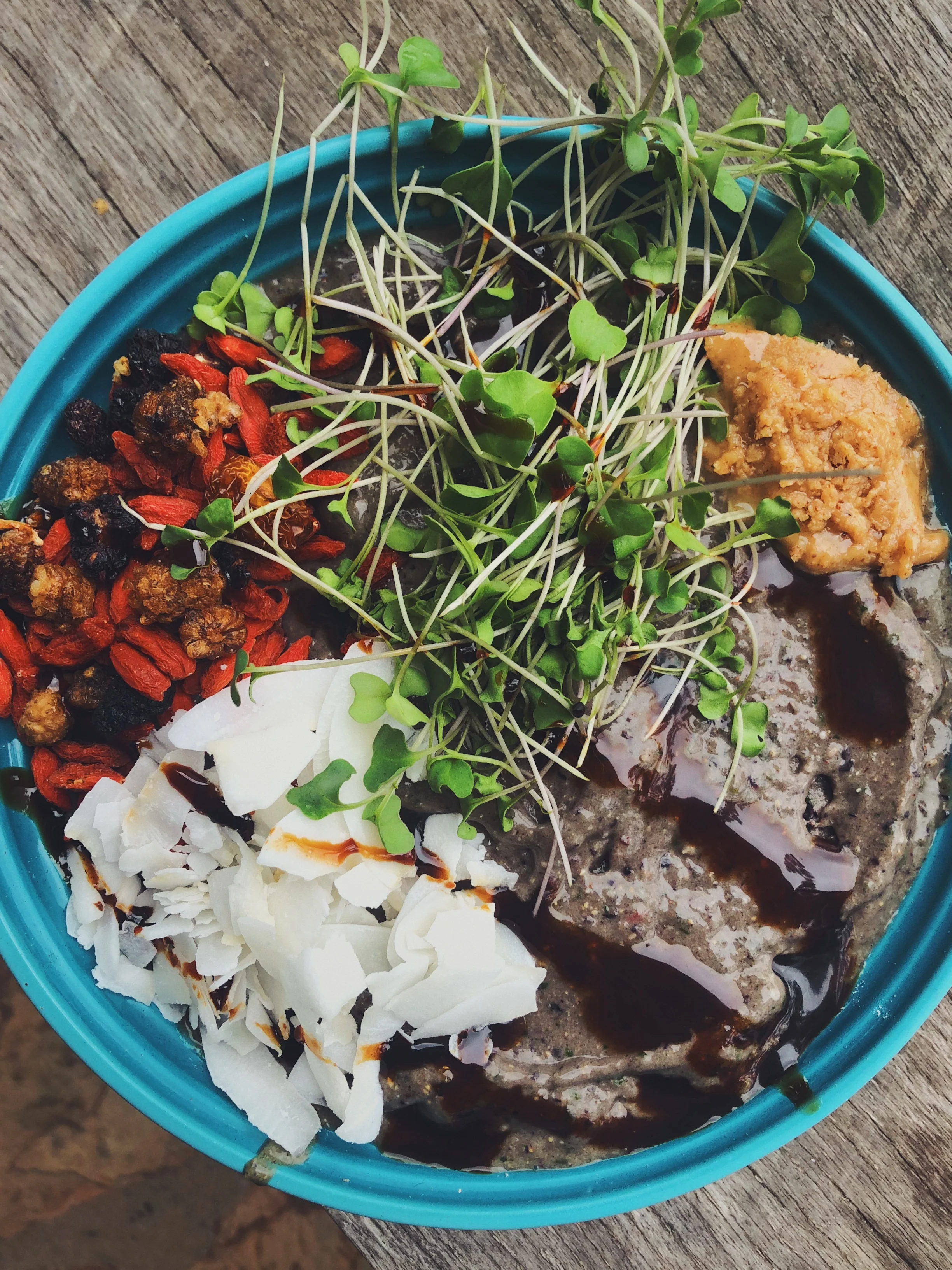 Nom it up with a morning smoothie bowl topped with coconut flakes, berries, sprouts, peanut butter and date caramel.