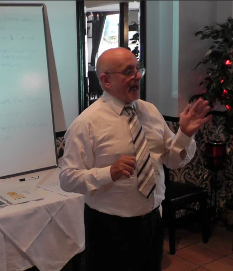Ernie SAID presenting at a formal business network event.