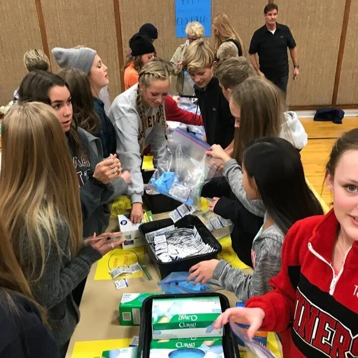   Volunteers prepare aid supply kits.  