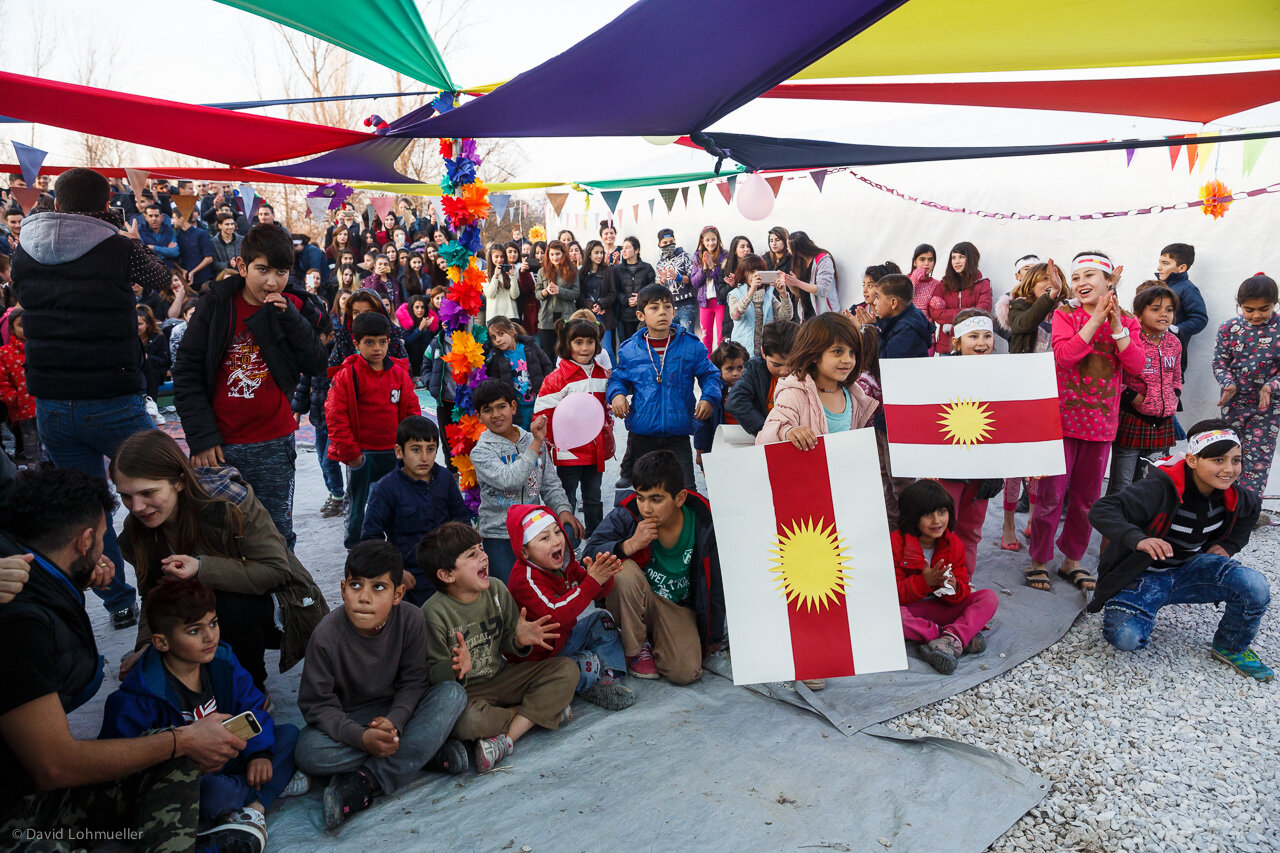   Yazidi children proudly display their flag at the 2018 grand opening of LHI’s Refugee Center.  