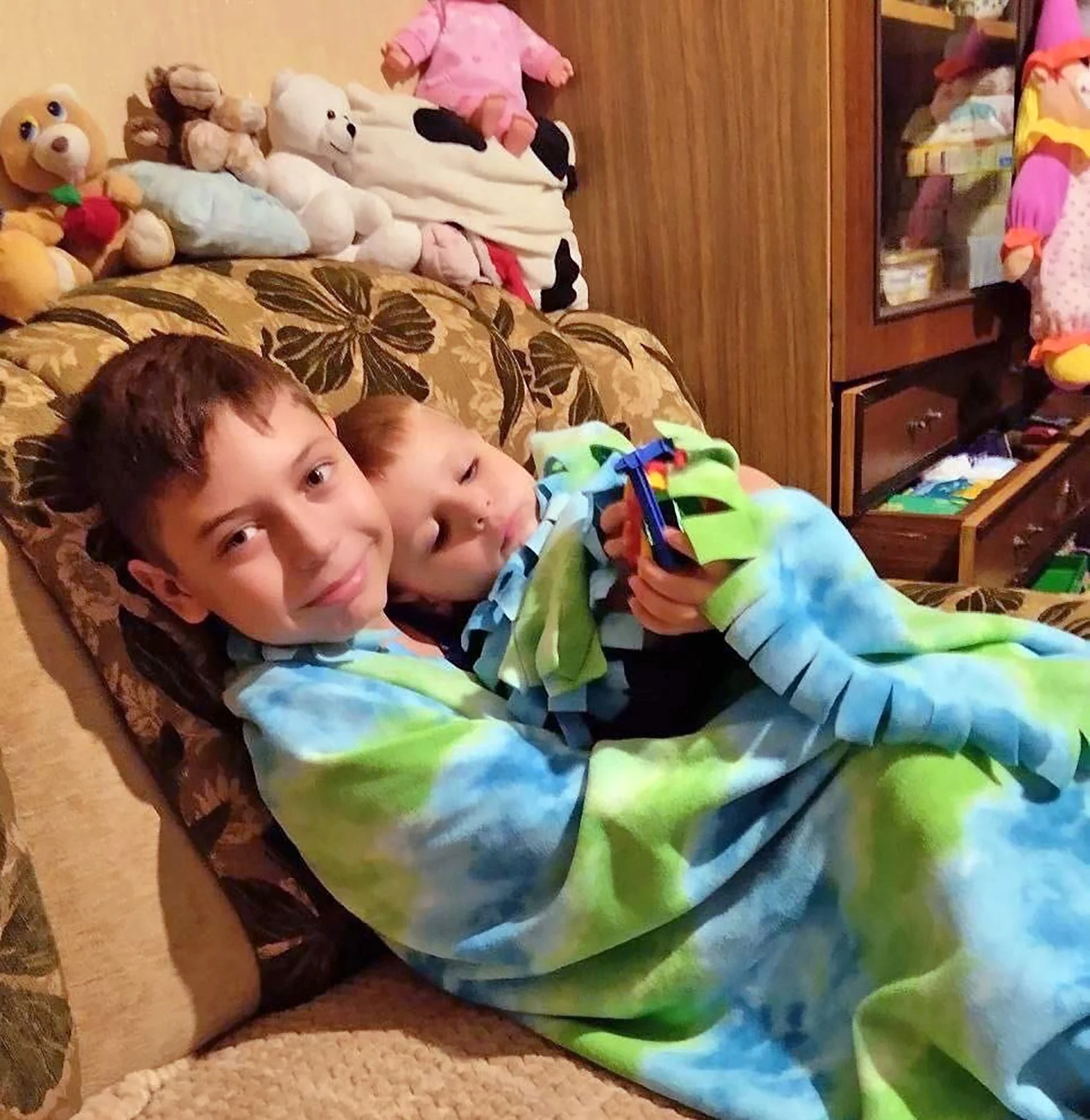  These boys who are snuggling under a blanket from an LHI aid distribution have been displaced from their homes by the war. 