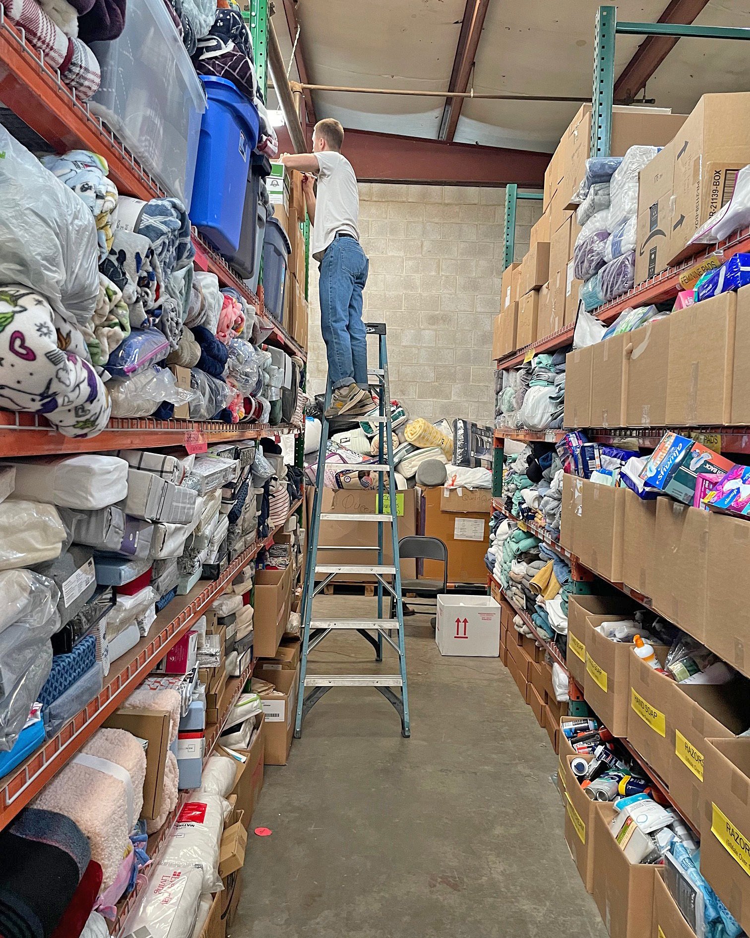  Nikita organizes shelves of aid that LHI includes in its international shipments. 