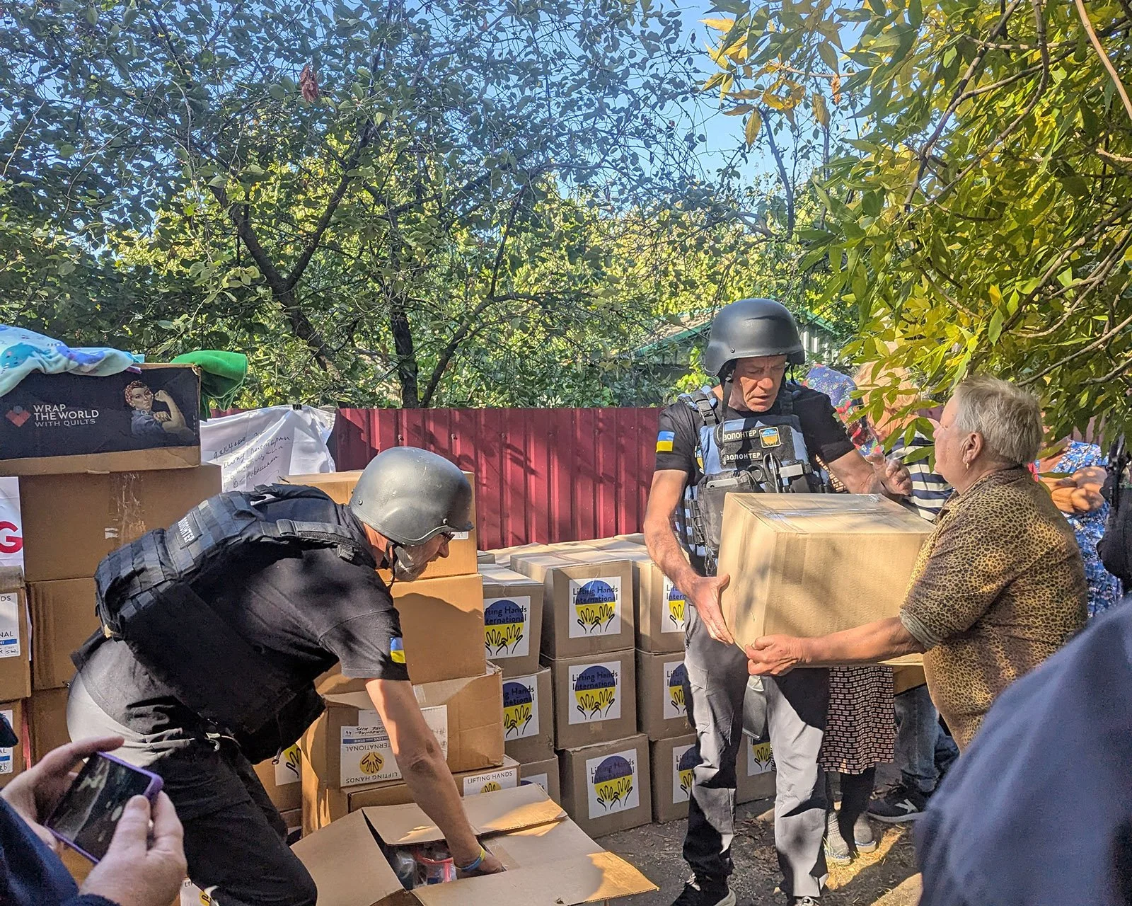  Distributing aid under the shelter of trees in Rozdol’ne. 