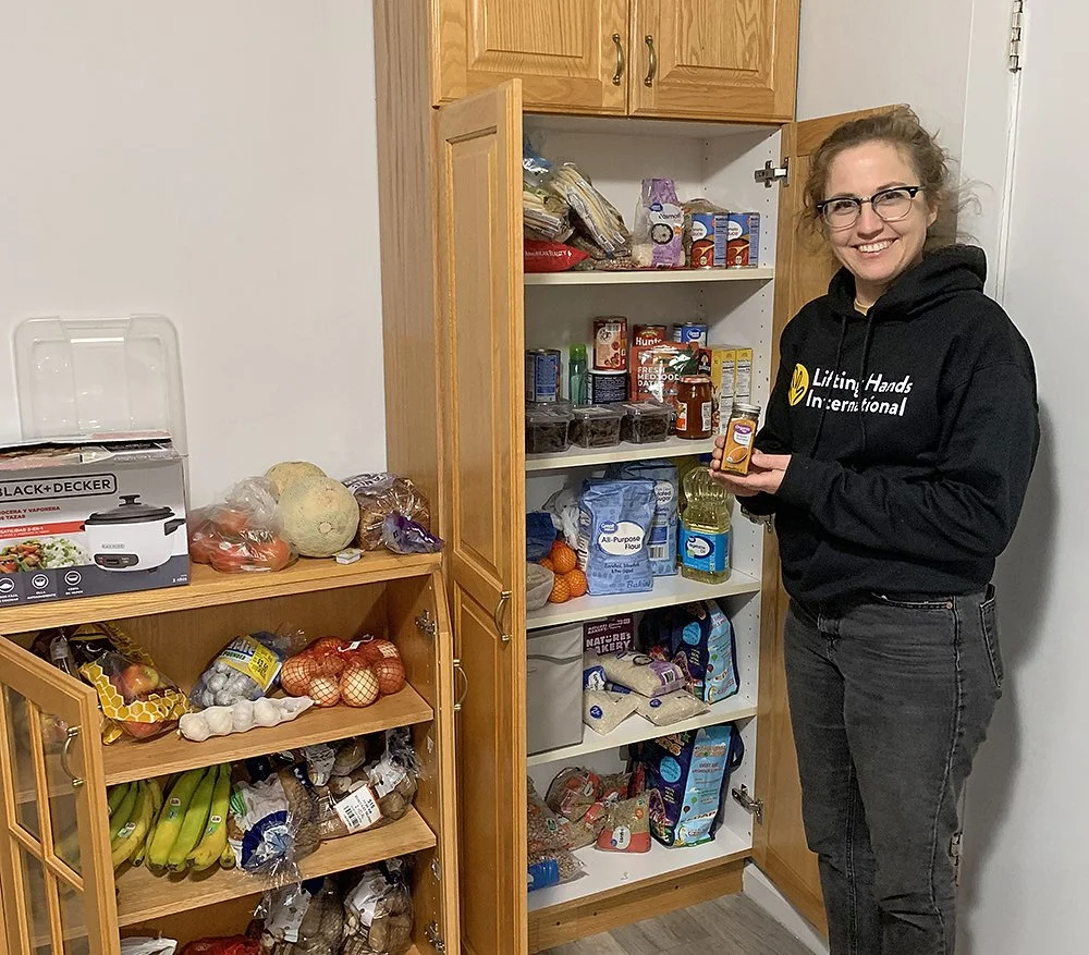 LHI Founder and Director Hayley Smith helping to stock the kitchen in an apartment we set up for a resettled family. 