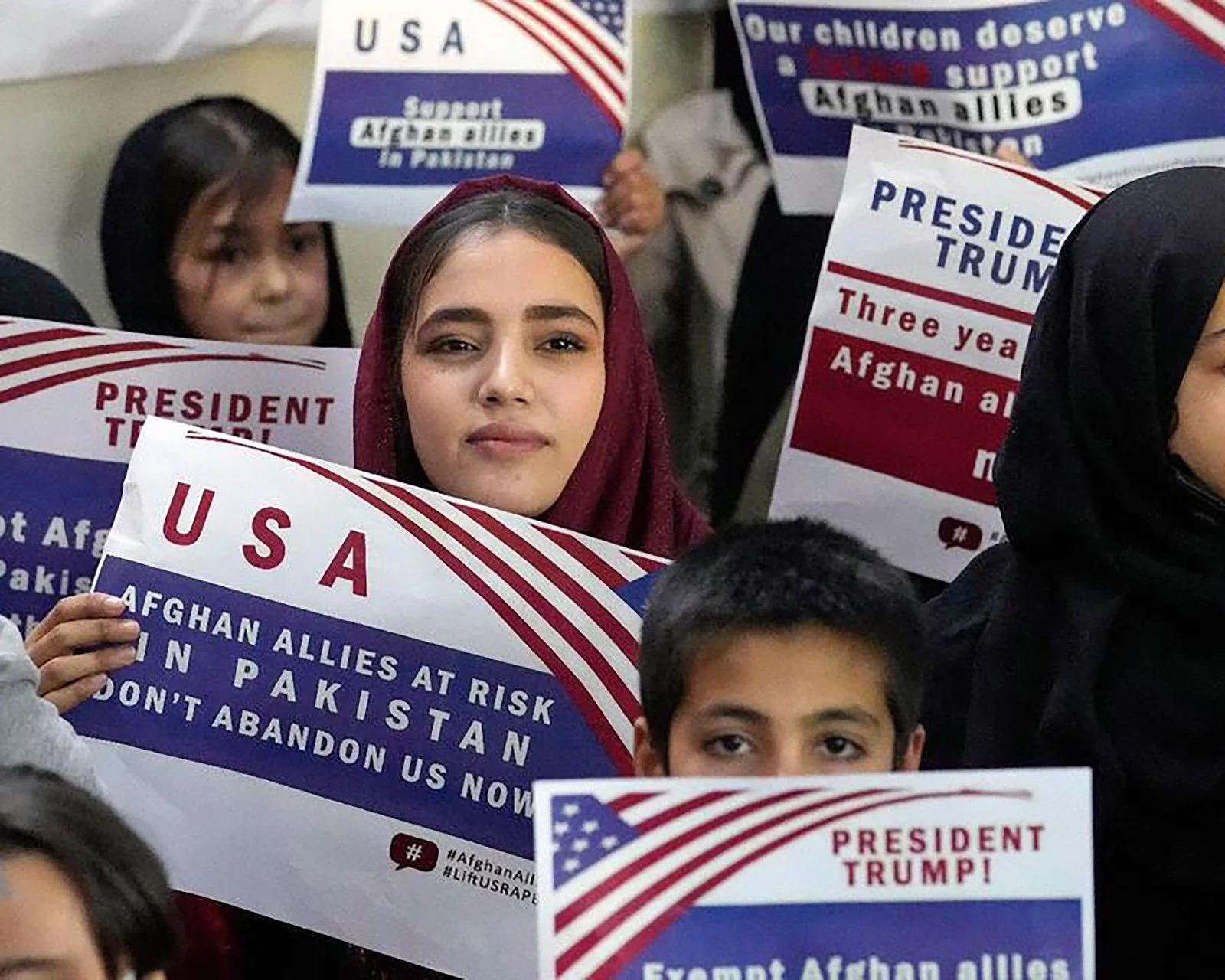  Afghan refugees hold placards during a meeting to discuss their situation after President Donald Trump paused US refugee programs, in Islamabad, Pakistan, Jan. 24, 2025. (AP Photo/Anjum Naveed) 