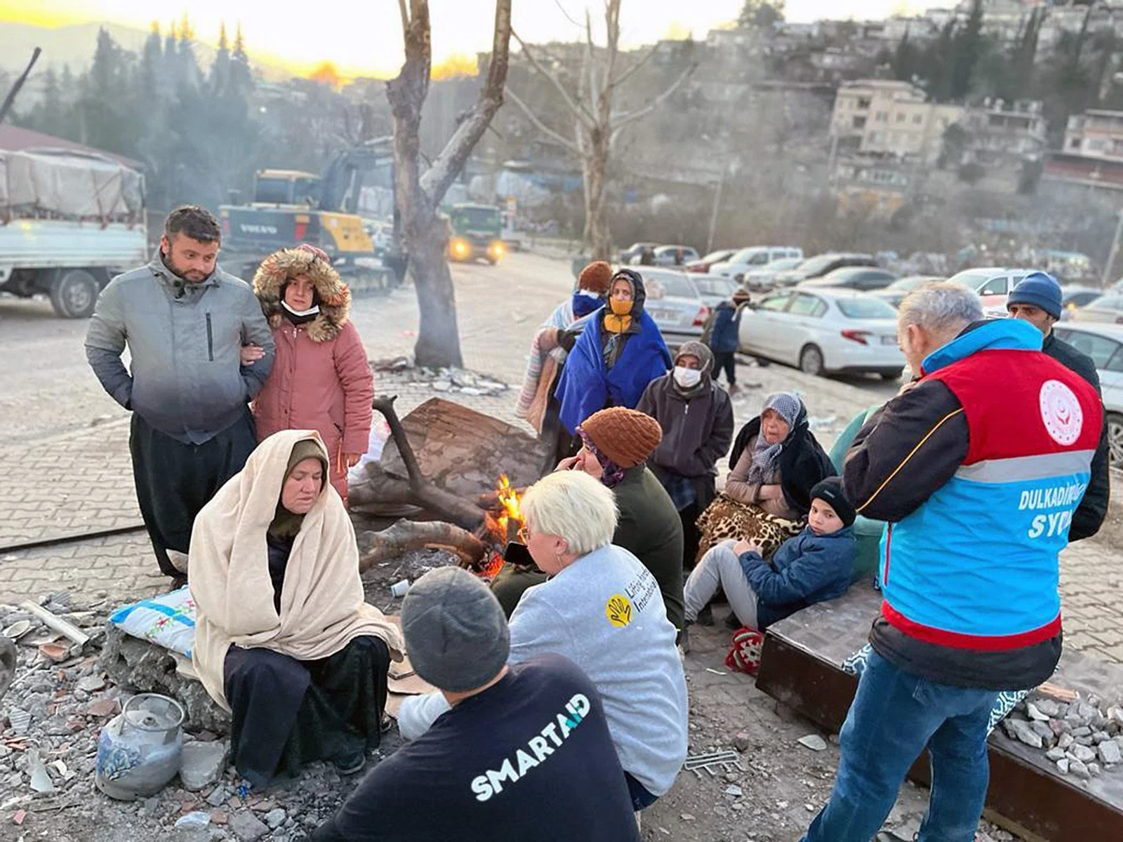  People whose homes had been destroyed by the earthquake talk to aid workers outside of their apartment buildings. 