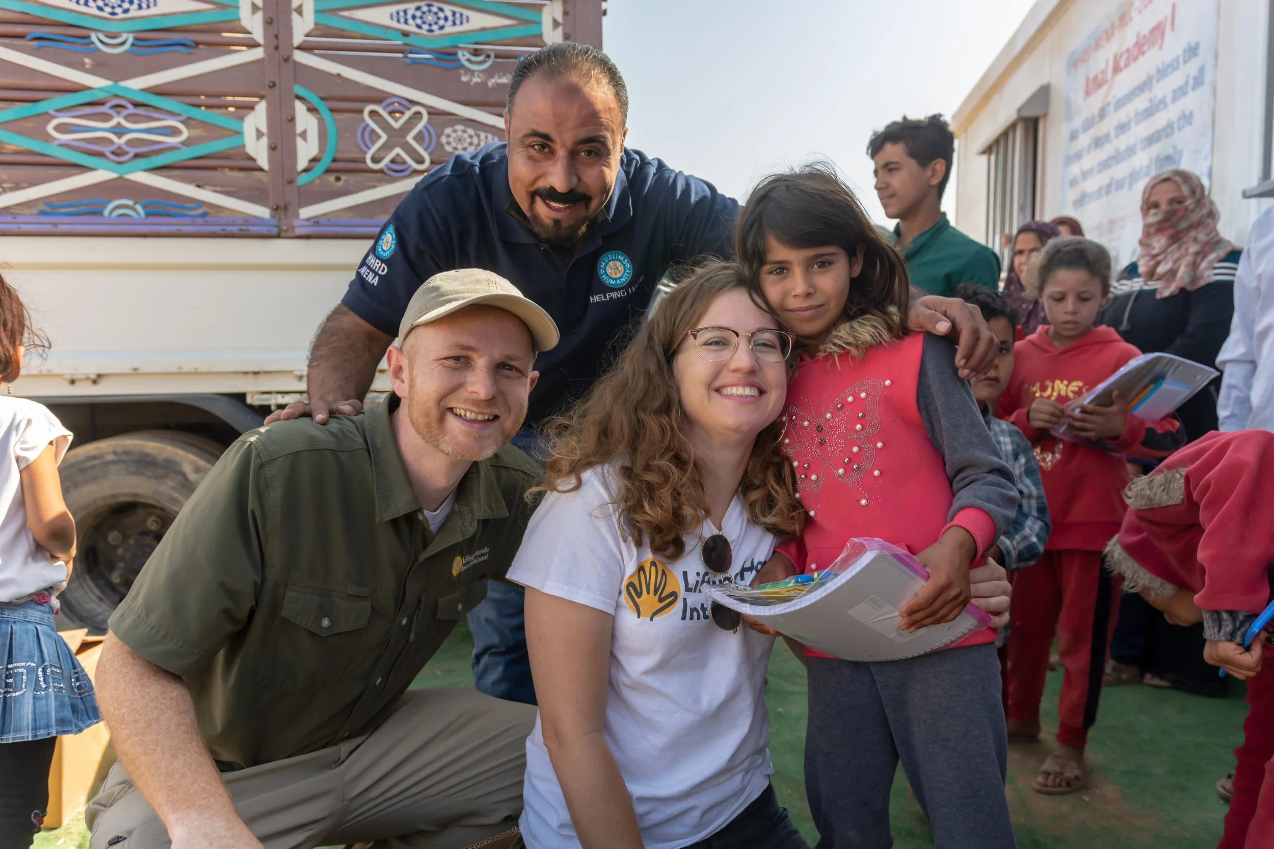  Walker, LHI COO, and Hayley, LHI Founder and Director, along with Hisham from our partner HHRD distribute school supplies to Syrian children who live in camps in northern Jordan. 