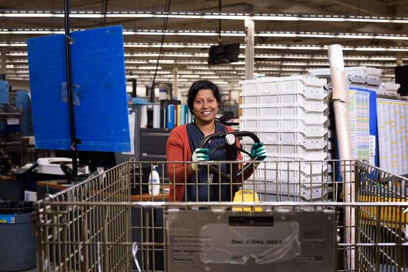 A postal worker operates a hand truck. I used one light on the subject to make the image pop.