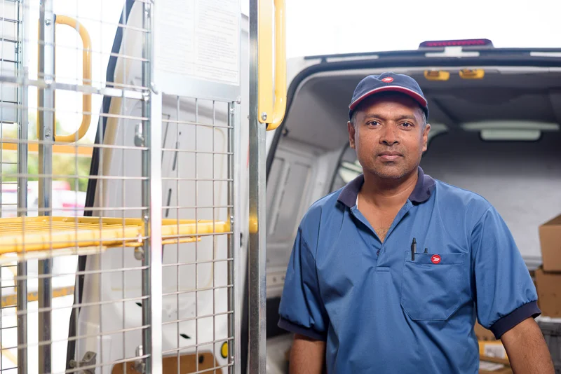 A mail carrier loads a truck for delivery. Sometimes it is ideal to overexpose the background to isolate the subject.