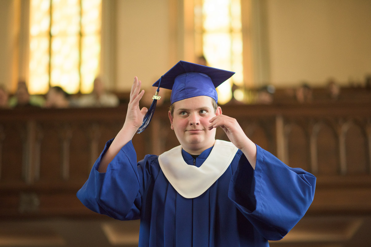 In this candid shot, a graduate moves the tassel on their graduation cap from one side to the other, signifying that they have received their diploma.