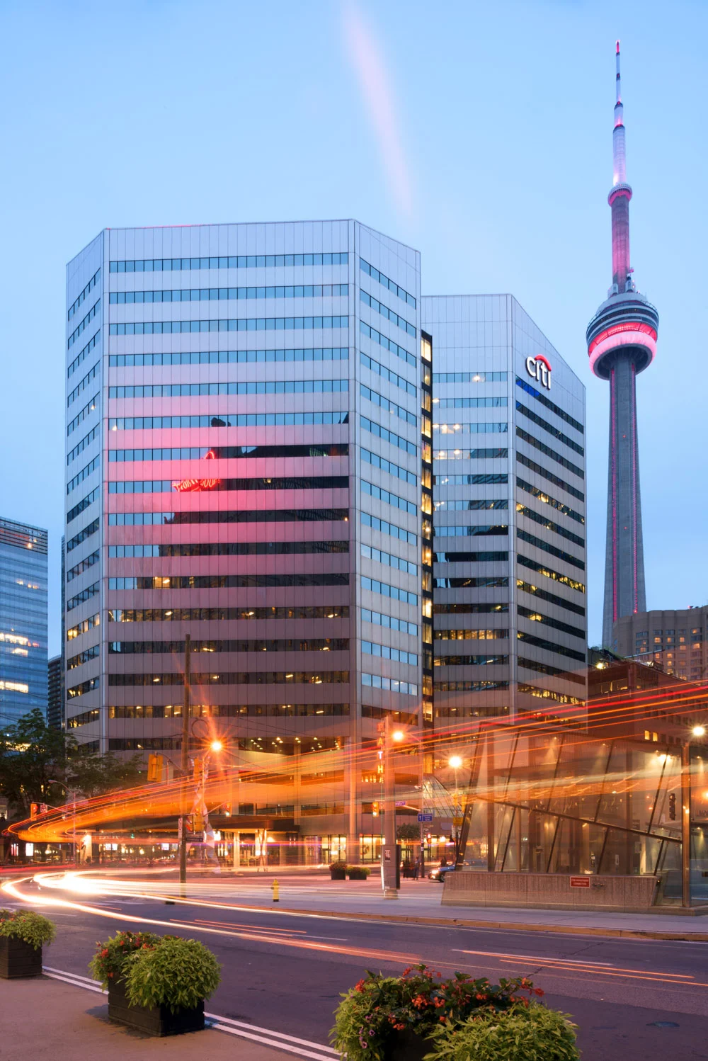 A bus motors past a building in Downtown Toronto, giving a a great blurring light effect in the foreground of this image. This is one example of creative use of shutter speed in photography. © Robert Lowdon