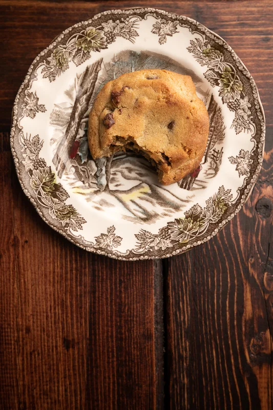 A cookies with a bite missing on a plate. © Robert Lowdon