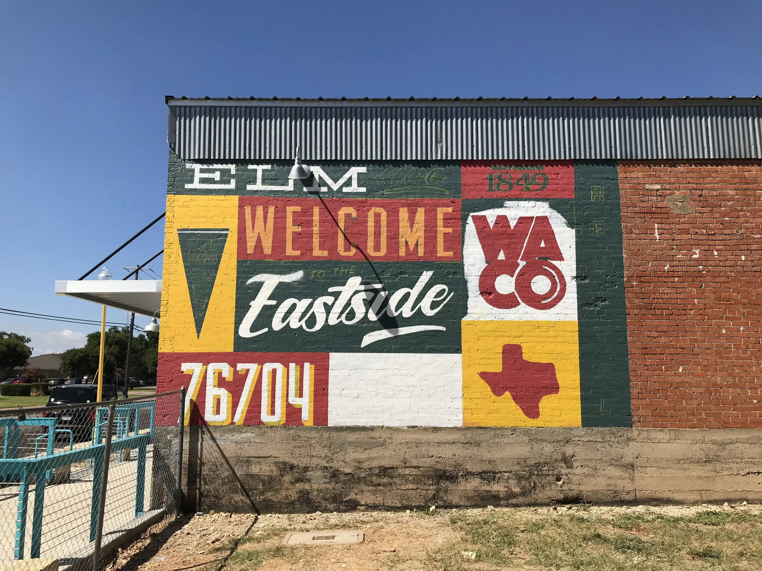 A mural on the side of Revival Eastside Eatery, a new restaurant on the blossoming Elm Avenue Corridor. It shares a block with a grocery store whose future is in jeopardy over a public funding disagreement.