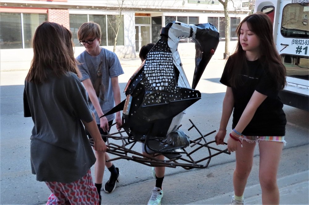  North Country School students carry their sculpture to the Adirondack Loon Center. 