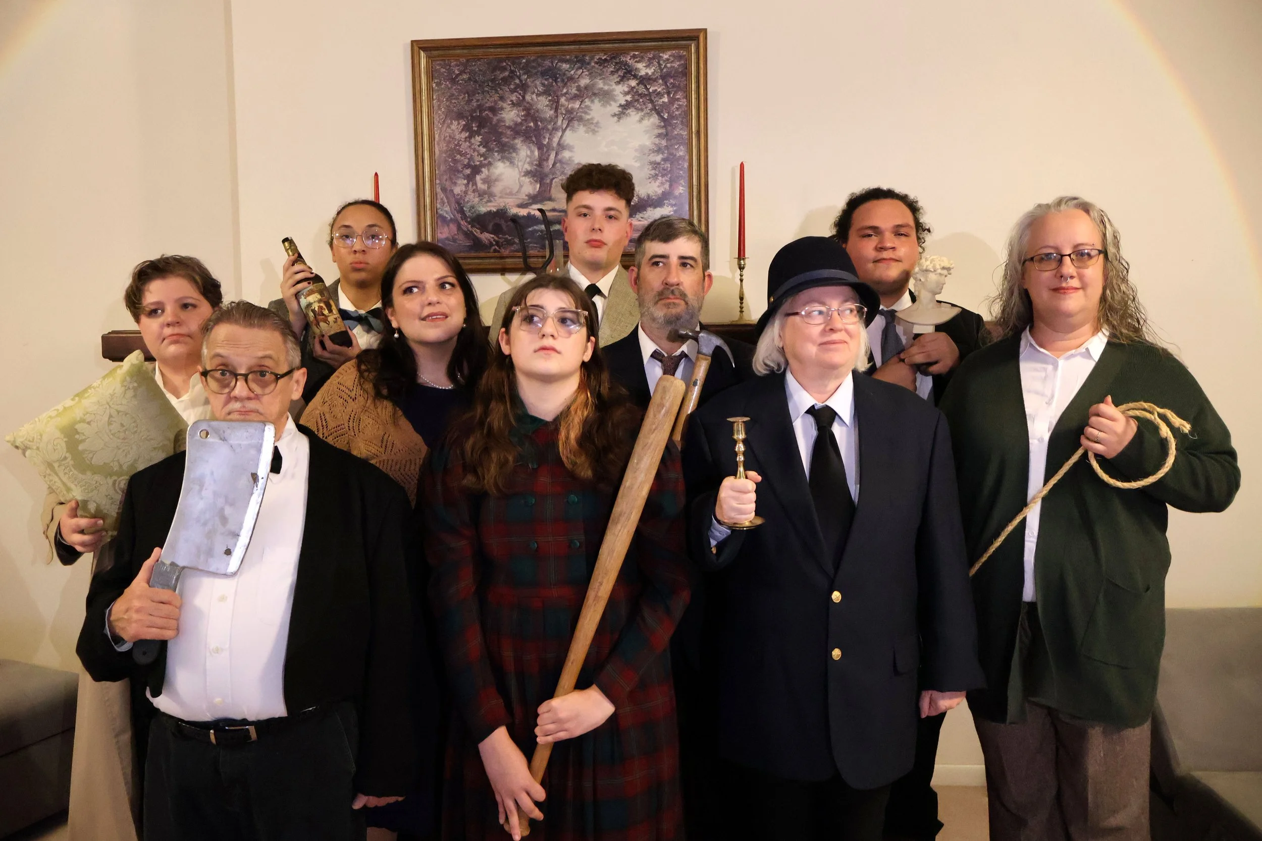 Spider's Web show photo featuring the cast looking very suspicious holding potential murder weapons.