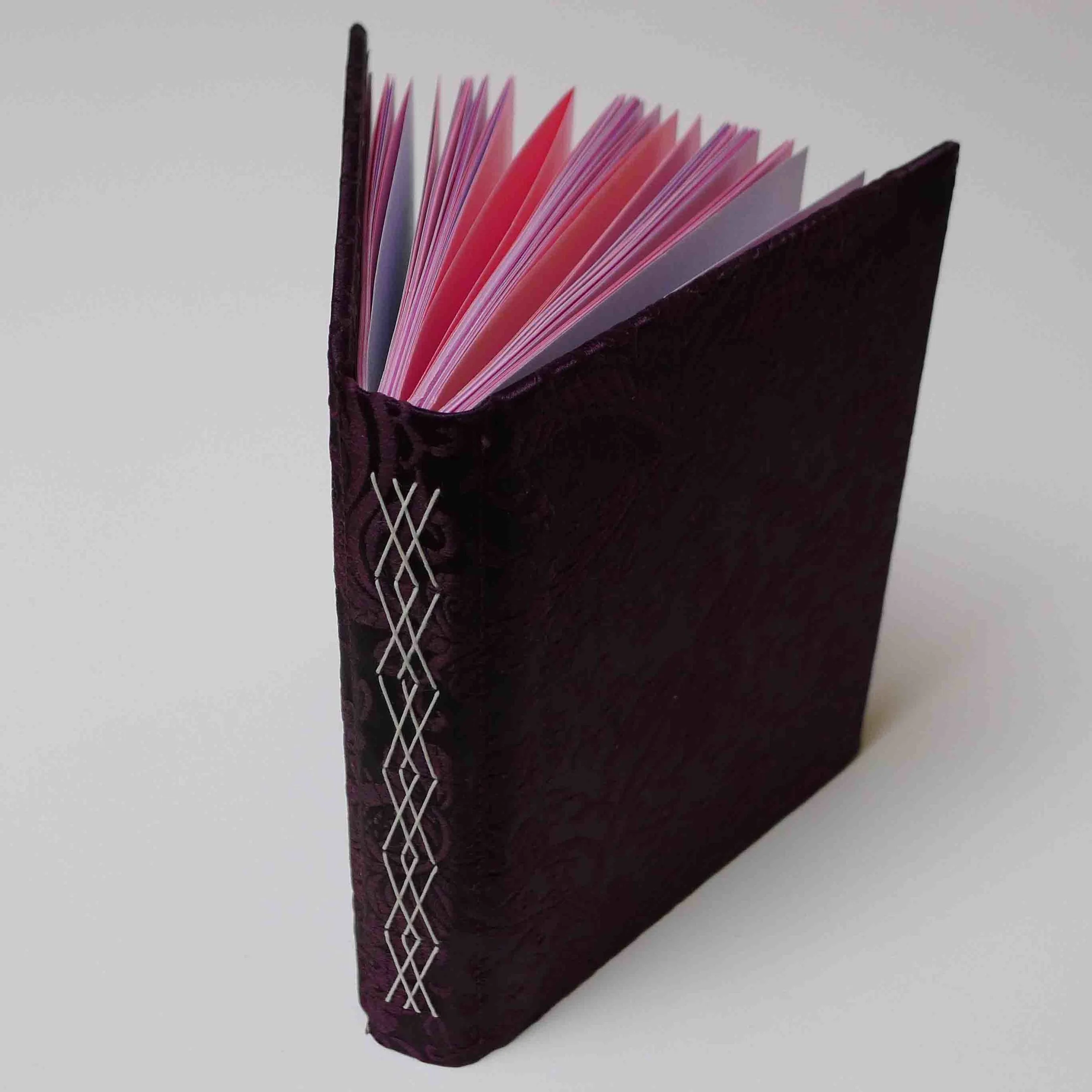 Fancy stitching through pairs of signatures, rigid cover