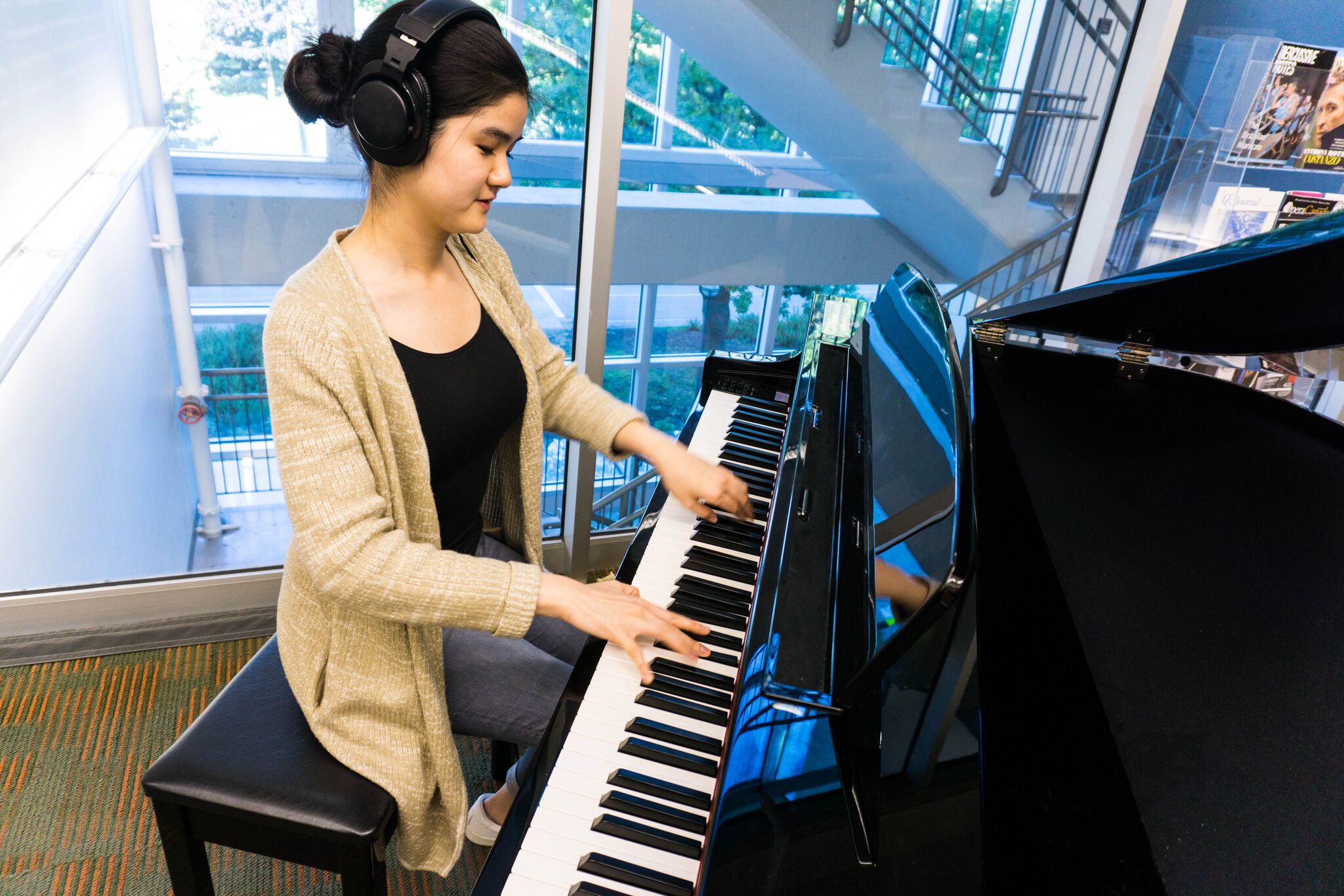 BMus student Serina Mui plays the new piano in the Music, Art and Architecture Library. The instrument is a gift from Tom Lee Music. Credit: UBC Library Communications