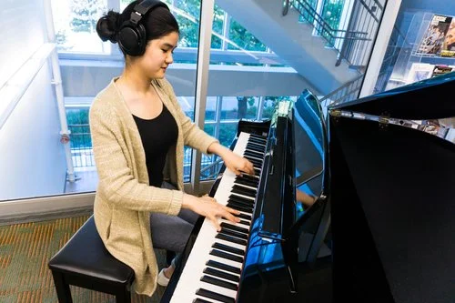 BMus student Serina Mui plays one of the donated pianos. Photo: UBC Library Communications