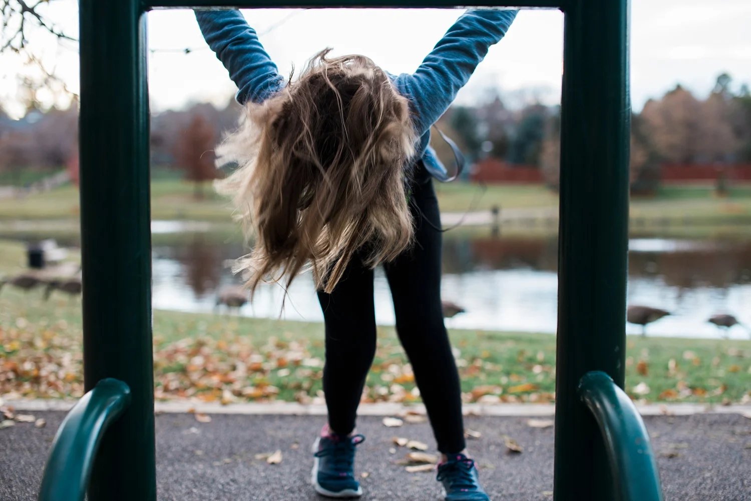 Our daughter flips on a bar at a local park during homeschooling recess. | GettingUnschooled.com