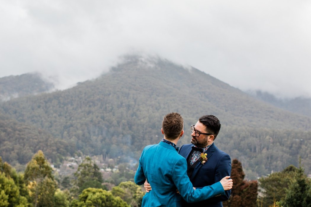 Same-sex couple overlooking misty mountain ranges during their wedding at Projekt 3488 in Warburton