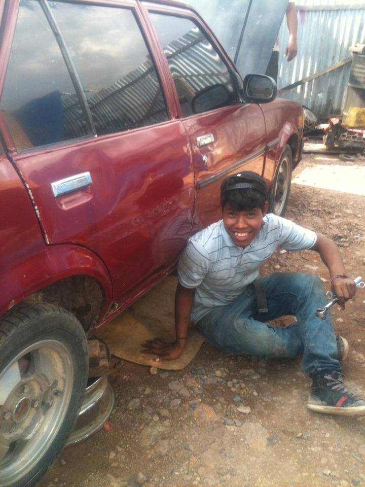 Geovanny working at a mechanic’s shop for his vocational training.
