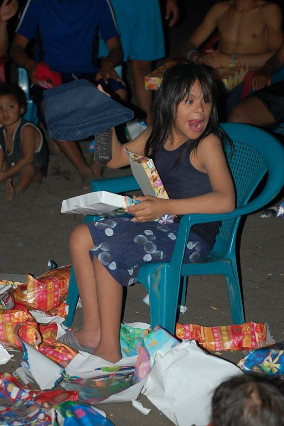 Brayan opens his presents during last year’s beach Christmas