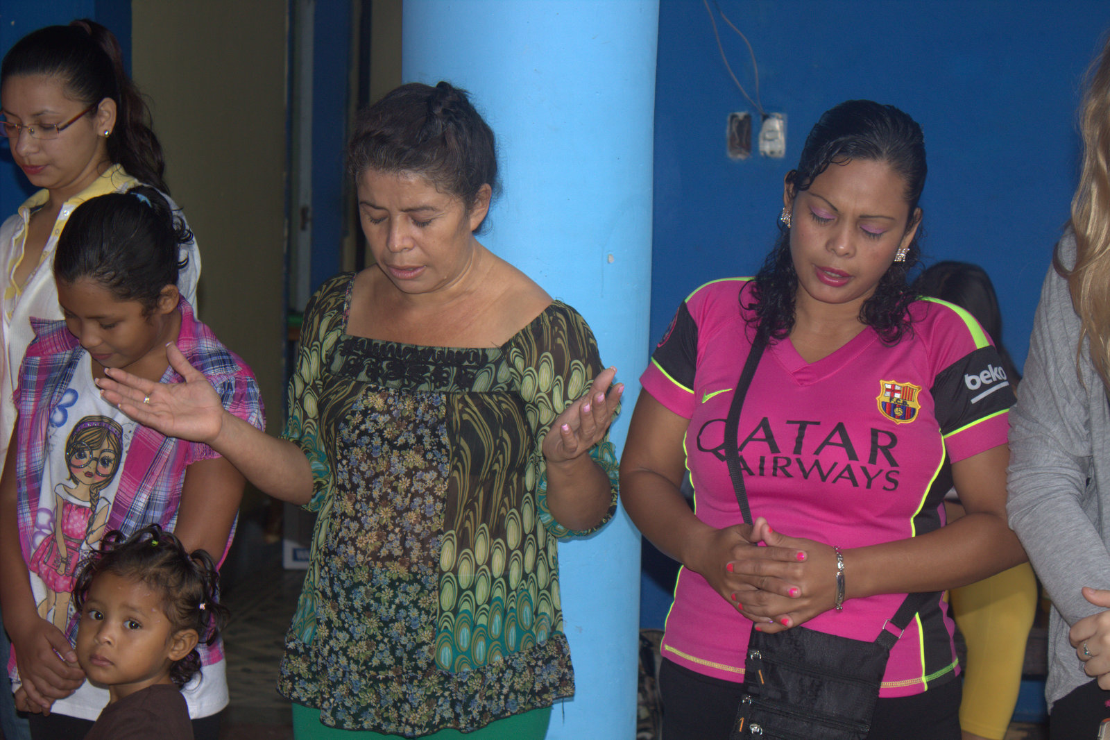 Martha (with hands raised) praying next to her niece, Escarlen, and sister, Edis, before last year's Beach Christmas trip